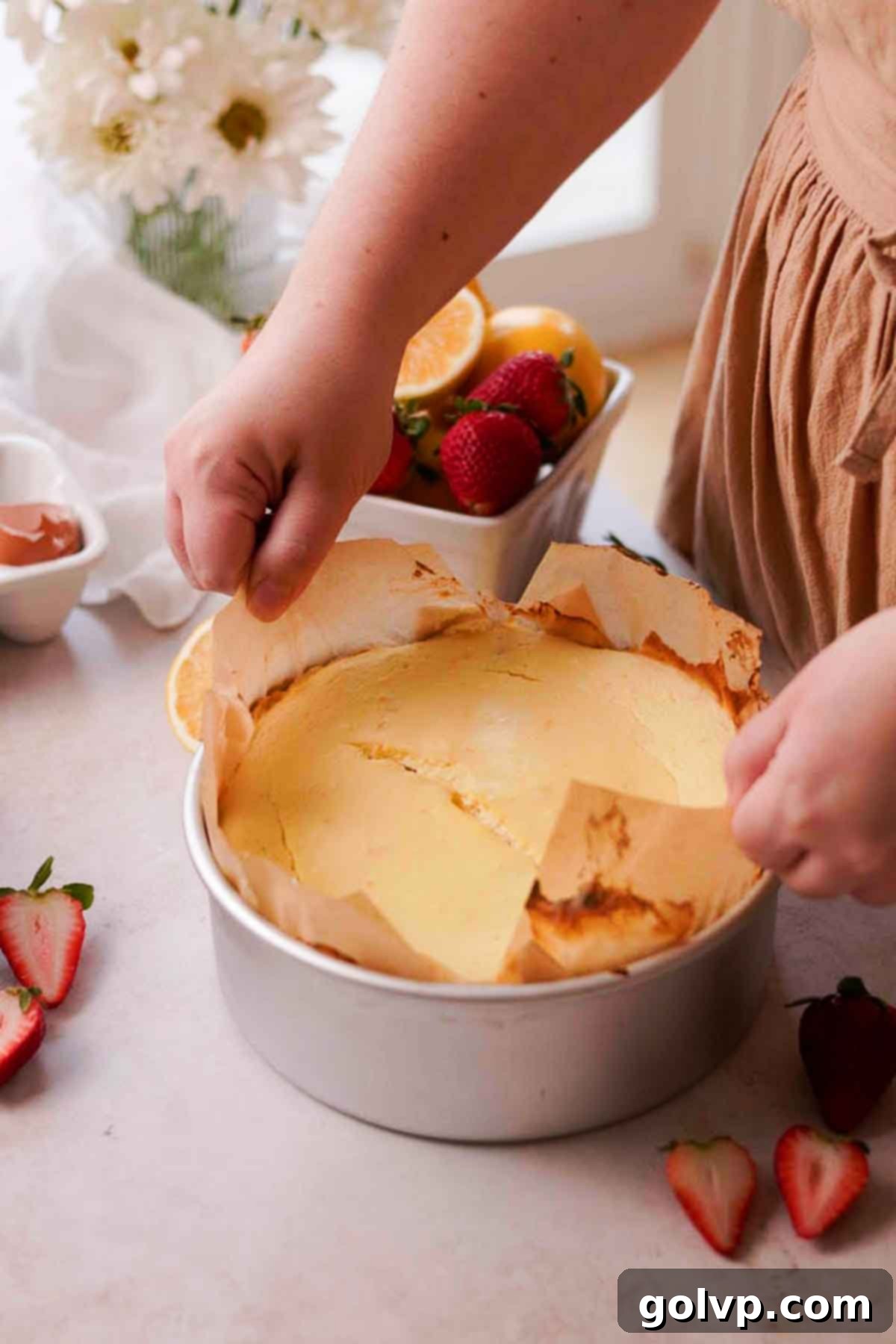 lifting baked cottage cheese cheesecake out of baking pan