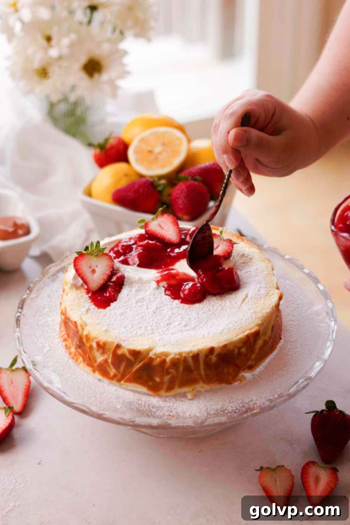 topping cottage cheese cheesecake with sour cream, strawberry jam, and fresh strawberries