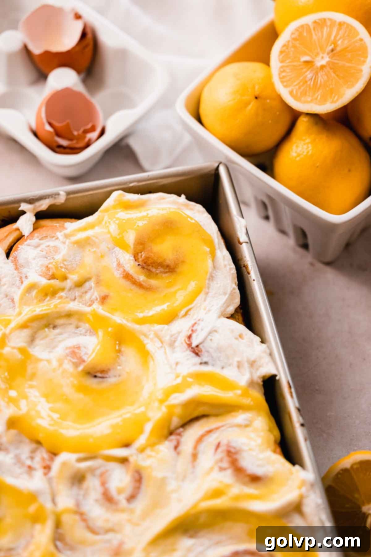 Freshly baked no-knead lemon sweet rolls in a baking pan, golden brown and ready for frosting.