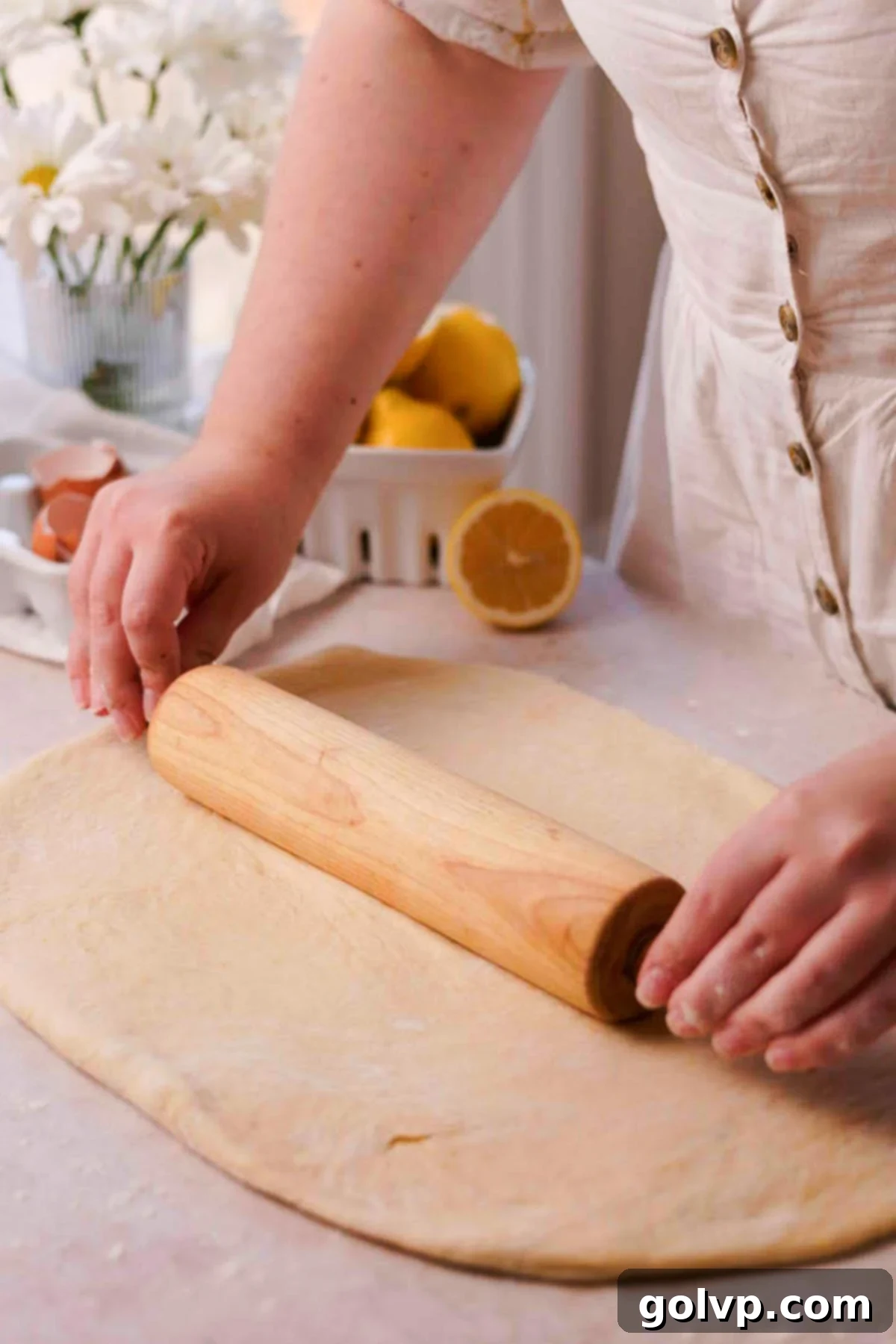 Rolling out the lemon sweet roll dough onto a lightly floured surface.