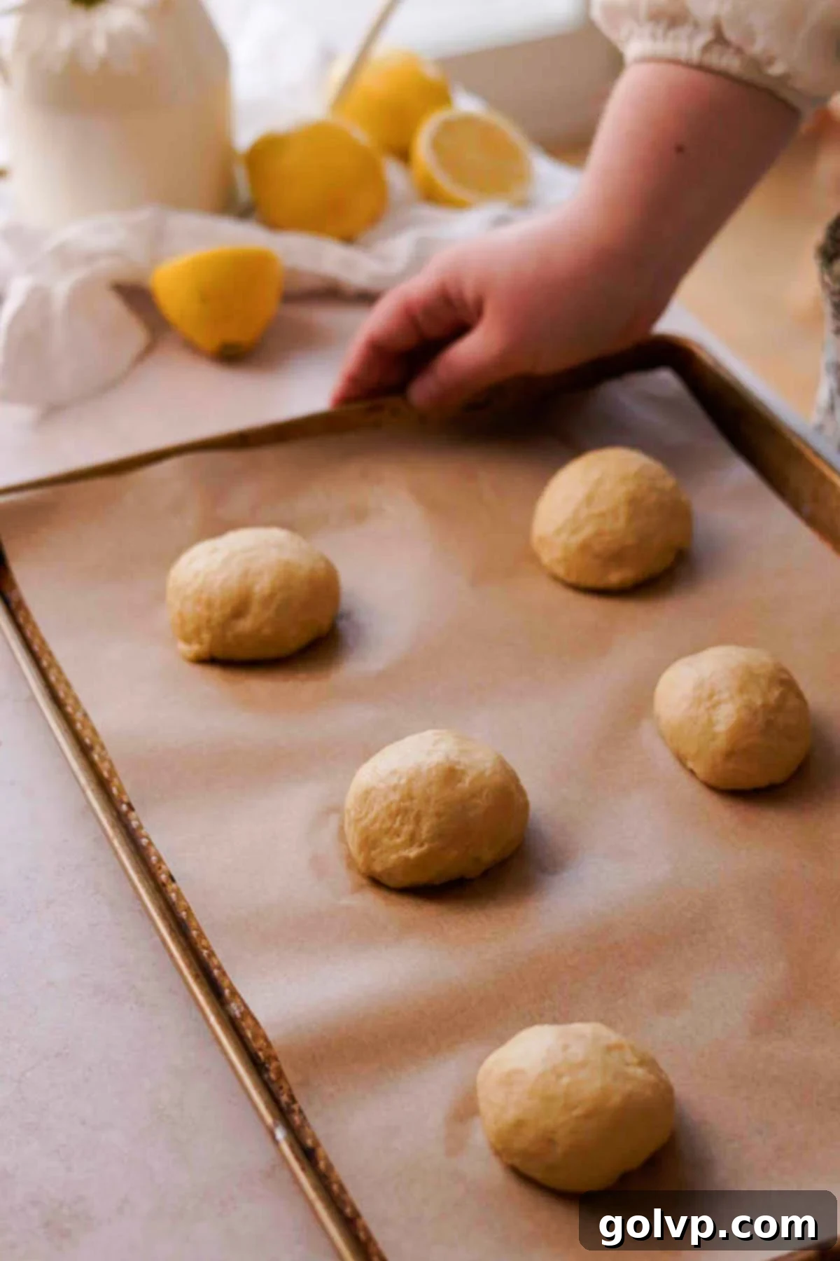 shaped brioche buns on parchment lined baking sheet