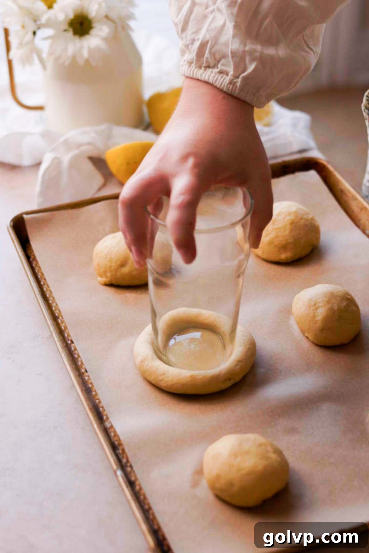 pressing the bottom of a glass into risen brioche buns