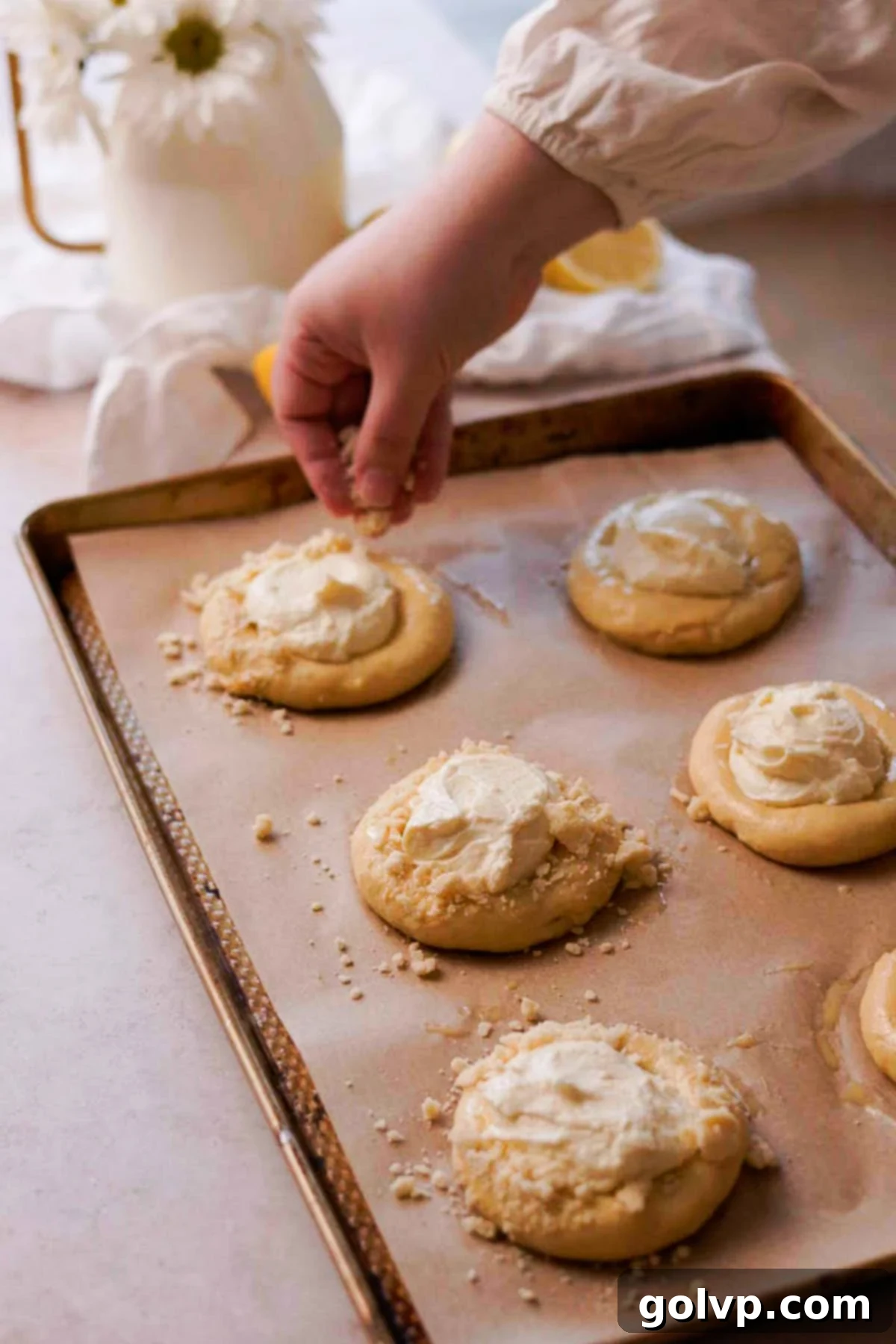 sprinkling streusel onto vatrushka buns