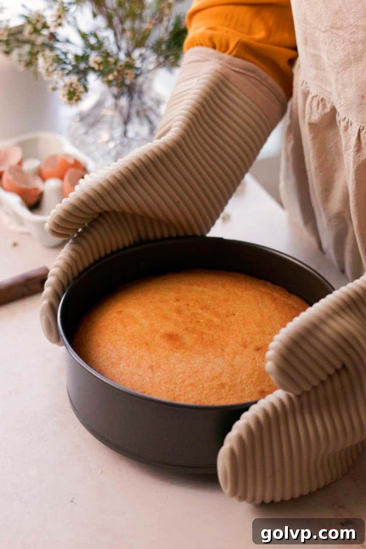 Double Almond Gooey Coffee Cake 10 holding baked almond coffee cake base in cake pan with oven mitts