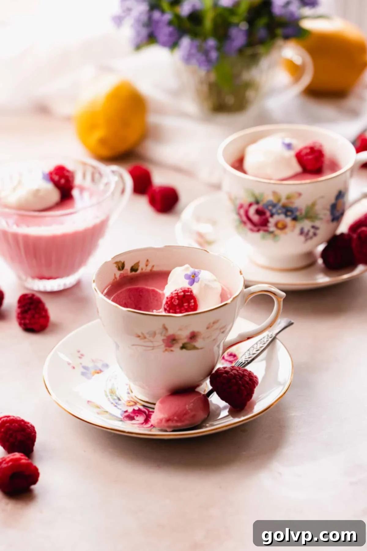 raspberry posset in teacups decorated with raspberries