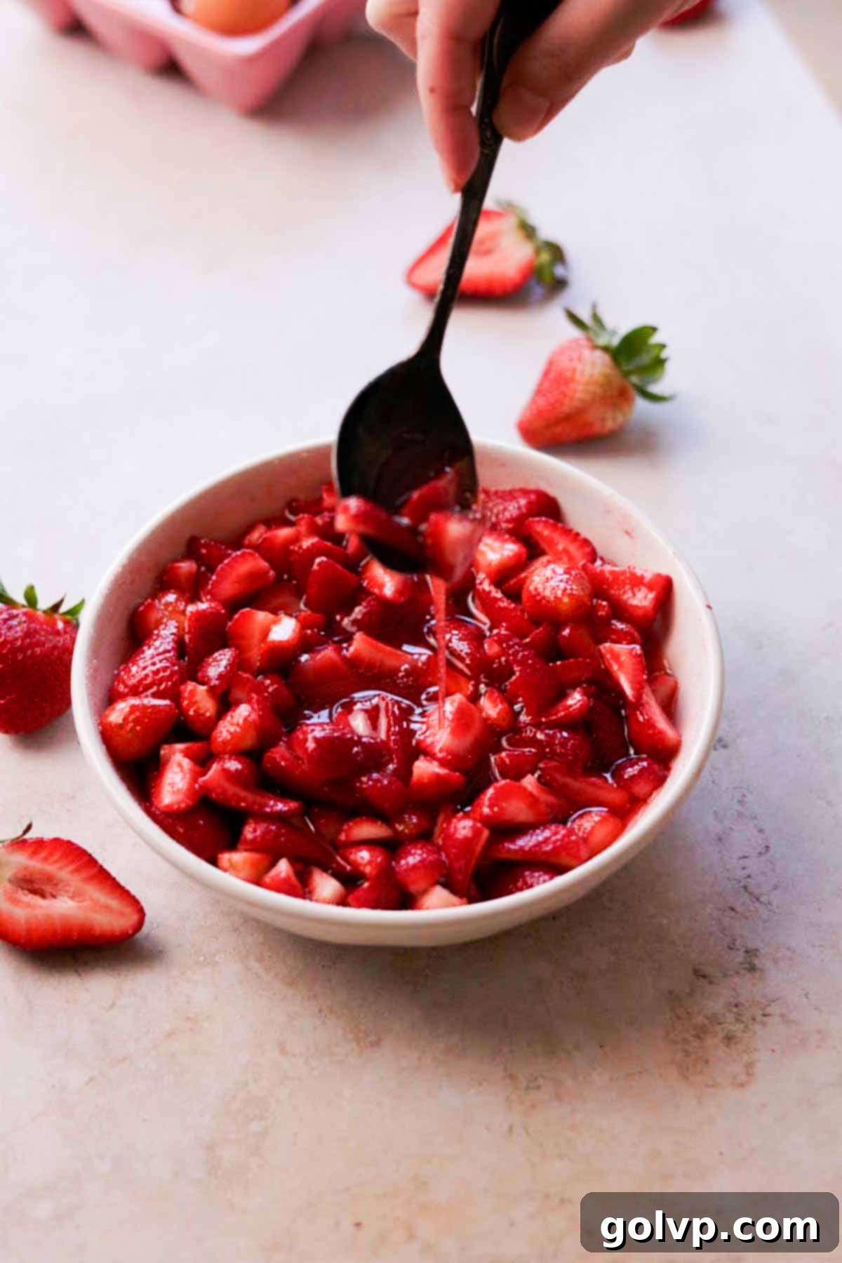 macerated strawberries in strawberry syrup, drizzling off the spoon