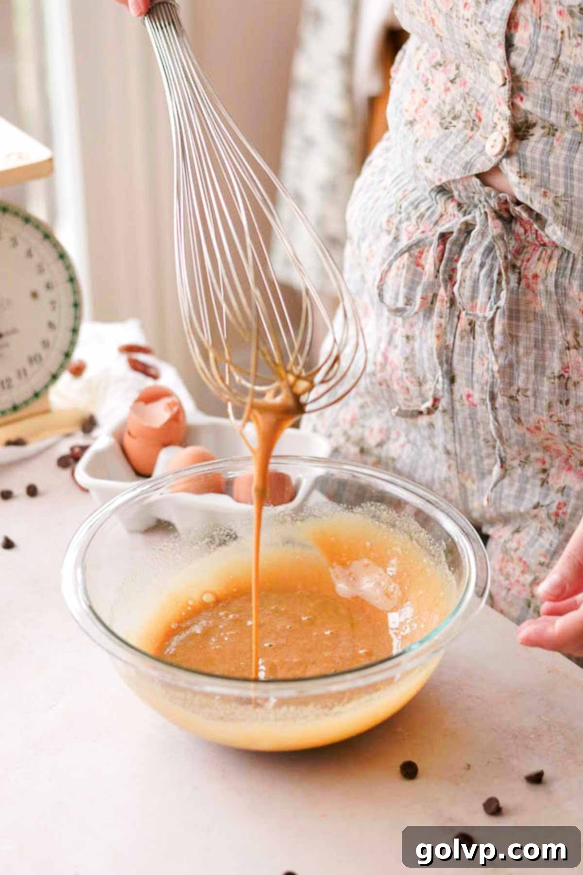 eggs and brown sugar being lightly whisked in a glass bowl for the pecan topping