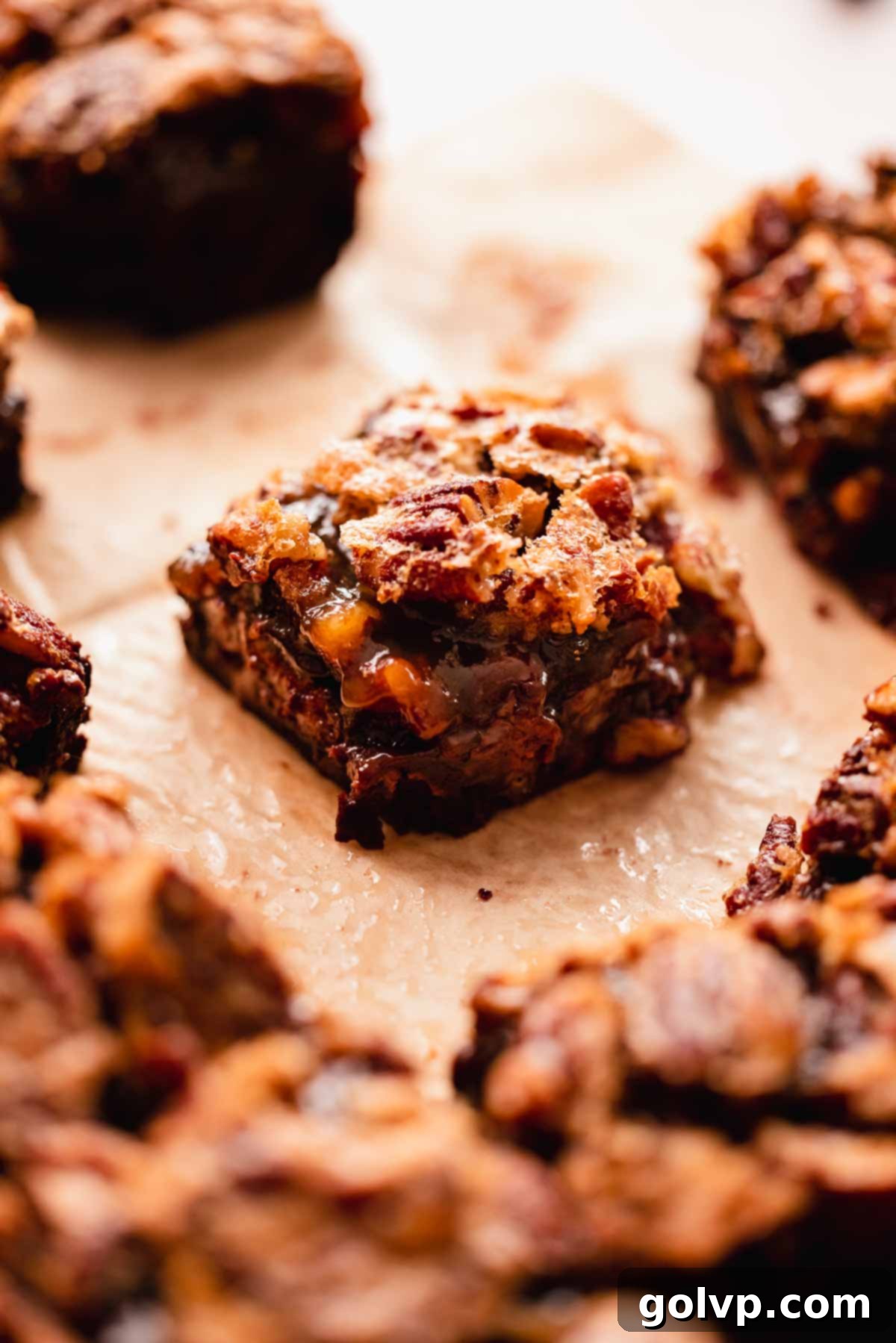 a single brownie square cut, showing the distinct fudgy chocolate layer and the gooey, pecan-crusted topping