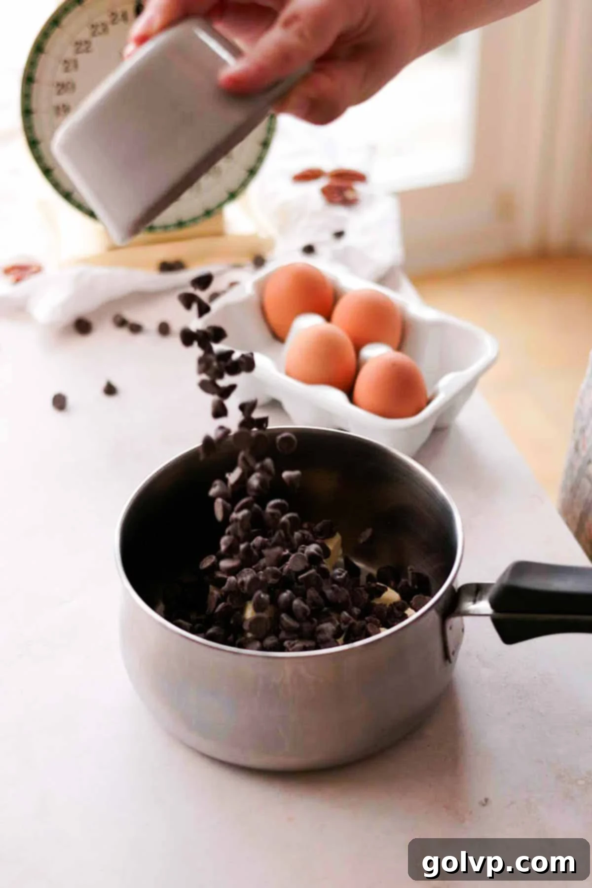 adding chocolate chips to a saucepan with butter over low heat