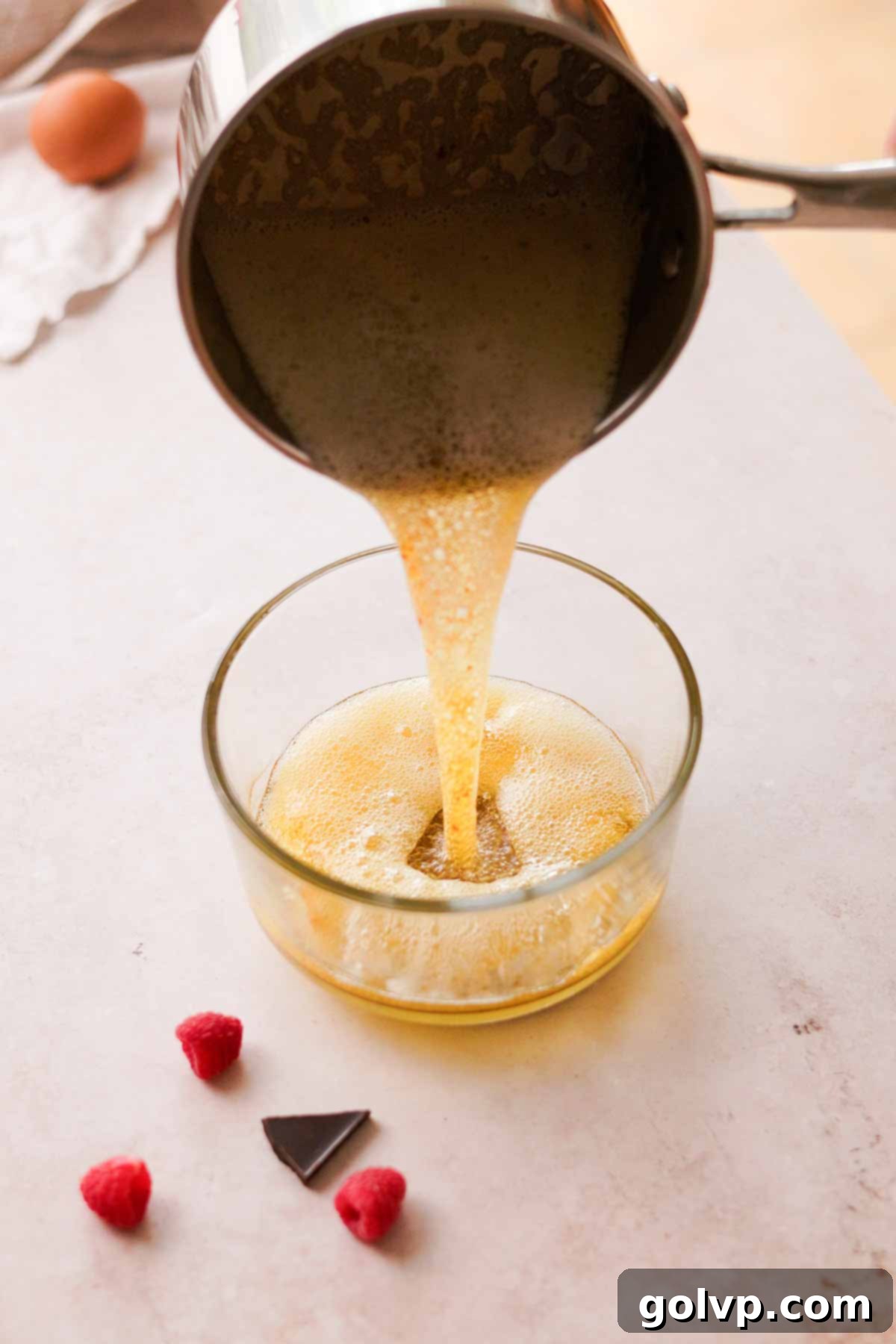 pouring the sizzling browned butter into a glass bowl