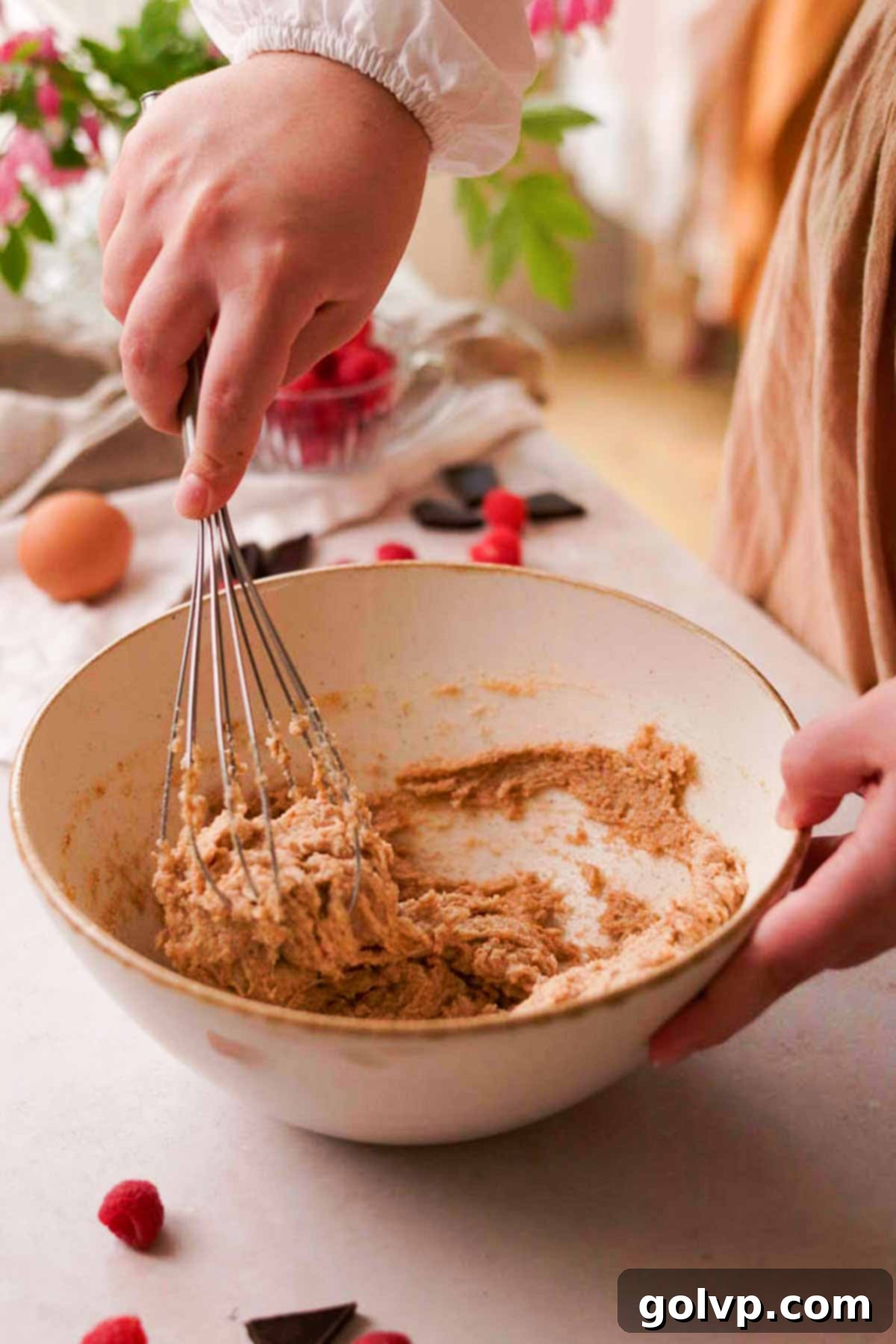mixing brown butter and sugar together in a bowl with a whisk