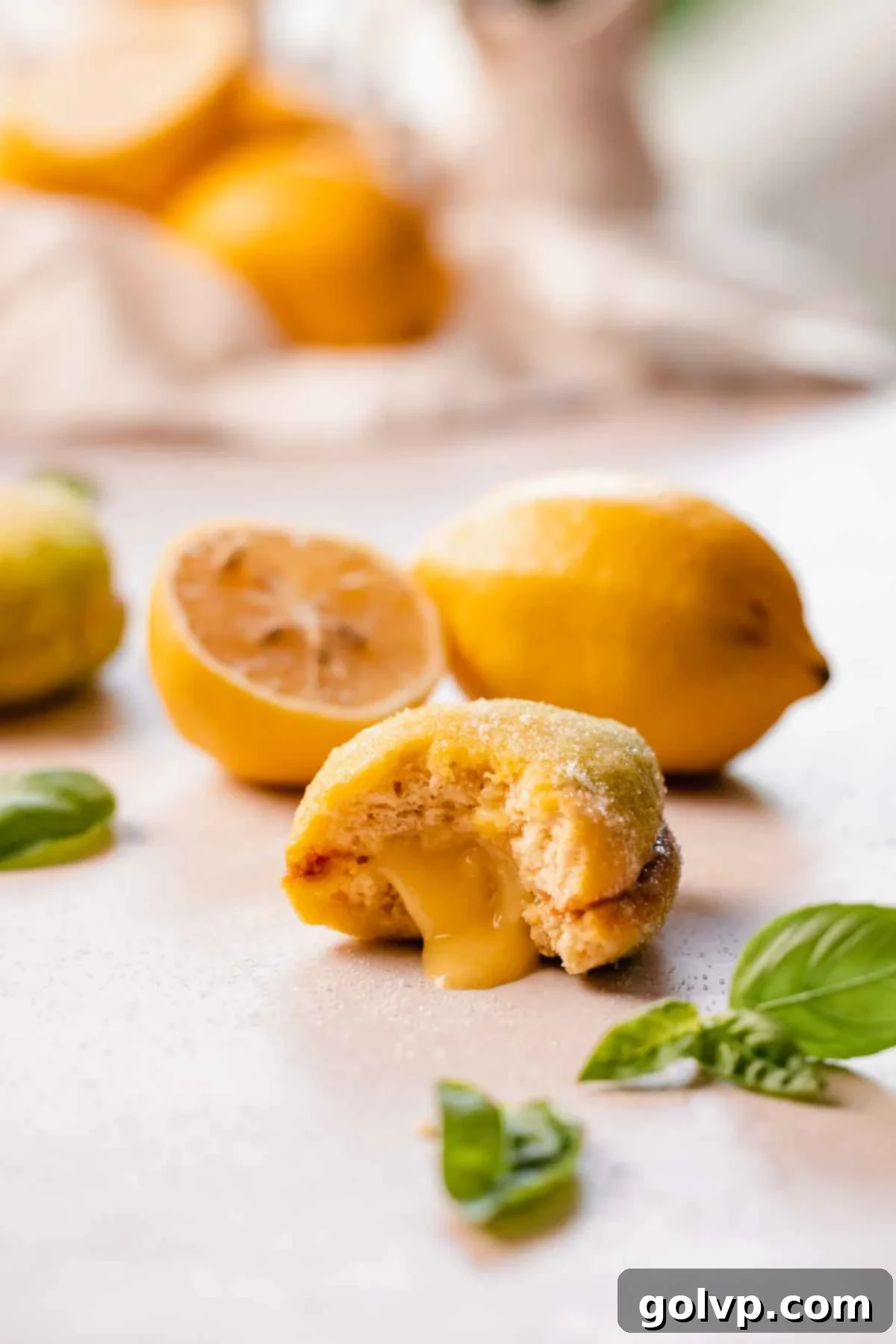 A perfectly bitten Italian lemon cookie revealing its luscious lemon curd filling and soft, moist interior. The vibrant yellow exterior is beautifully contrasted with the creamy, tangy filling.