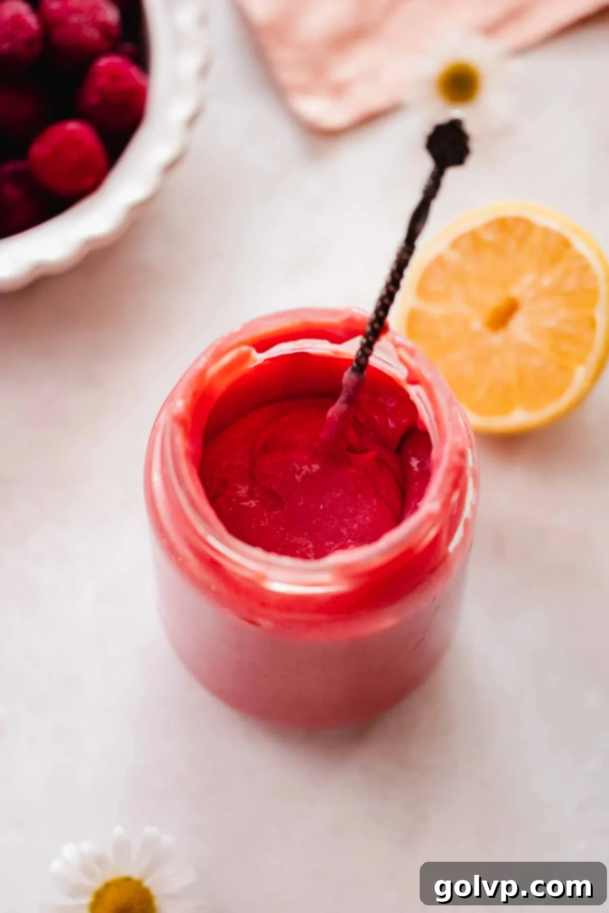 thick cherry curd in a jar with a silver spoon sticking out