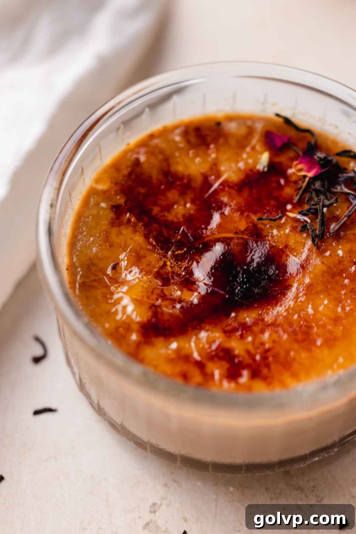 A freshly torched Earl Grey Crème Brûlée, showing the shiny, hard caramel layer, ready to be cracked.