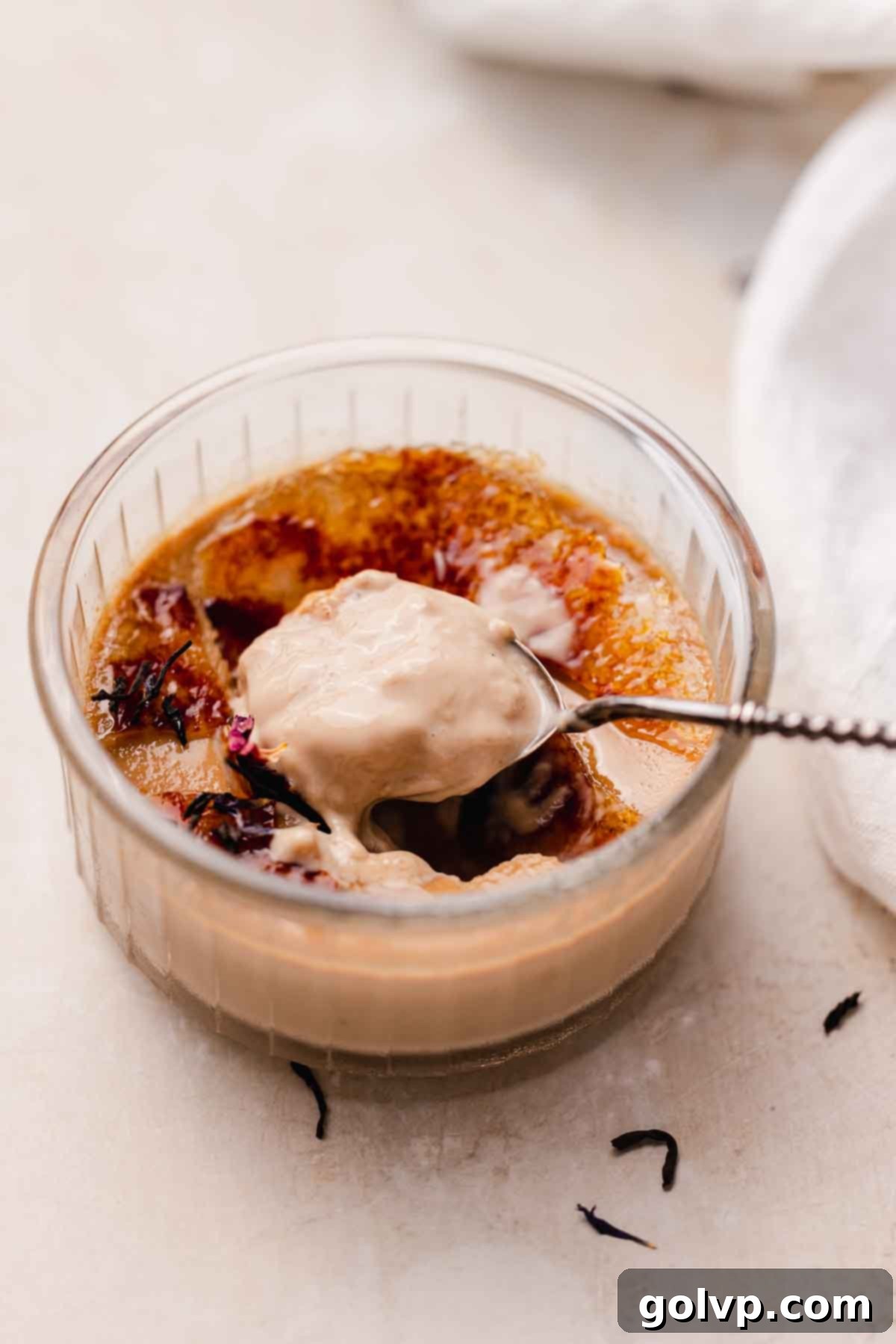 Stack of freshly prepared Earl Grey Crème Brûlée ramekins, showing the creamy texture beneath the torched sugar.