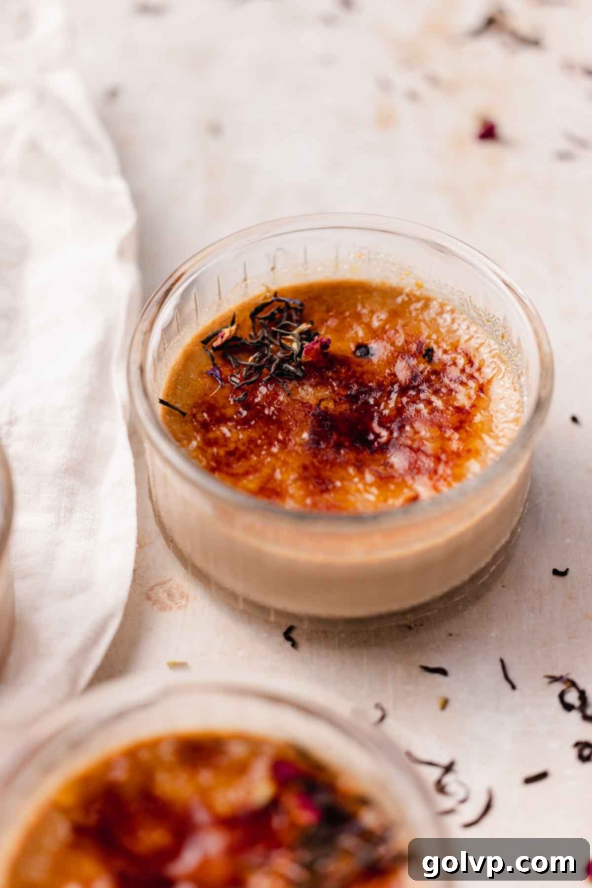 Close-up of a perfectly torched Earl Grey Crème Brûlée, showcasing the crisp, golden caramel topping.
