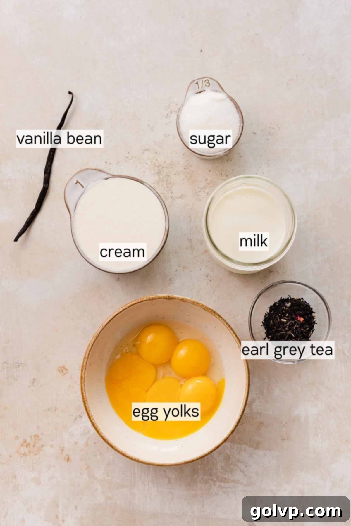 Selection of key ingredients for Earl Grey Crème Brûlée, including milk, Earl Grey tea, vanilla bean, egg yolks, and heavy cream.