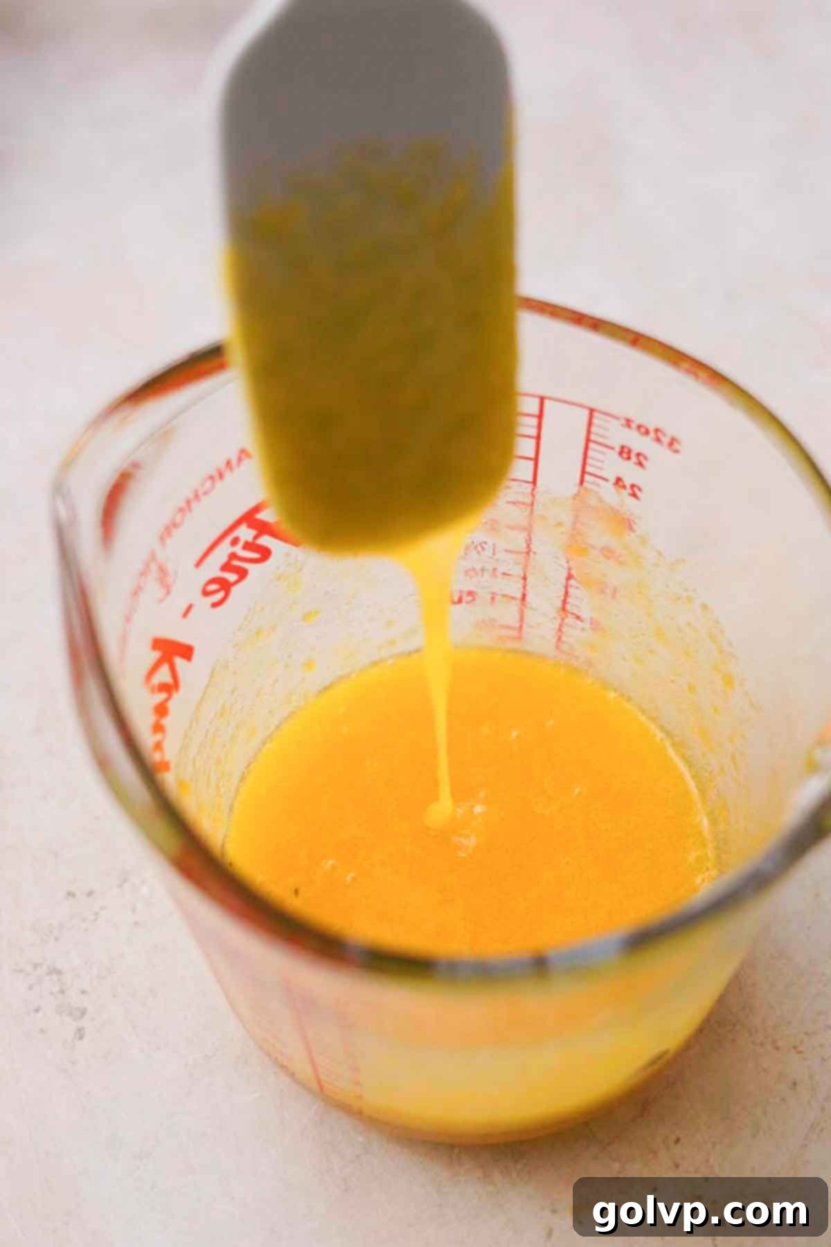 Egg yolks and sugar being stirred in a bowl