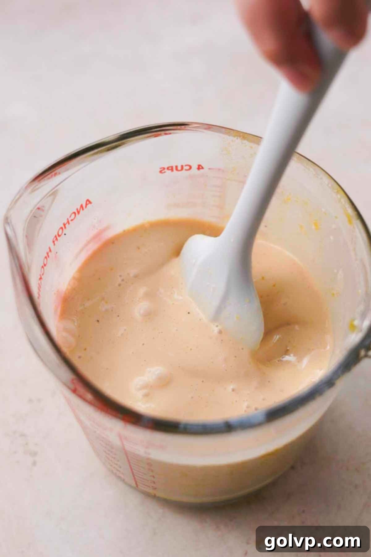 Heavy cream, infused milk, and salt being added to egg yolk mixture