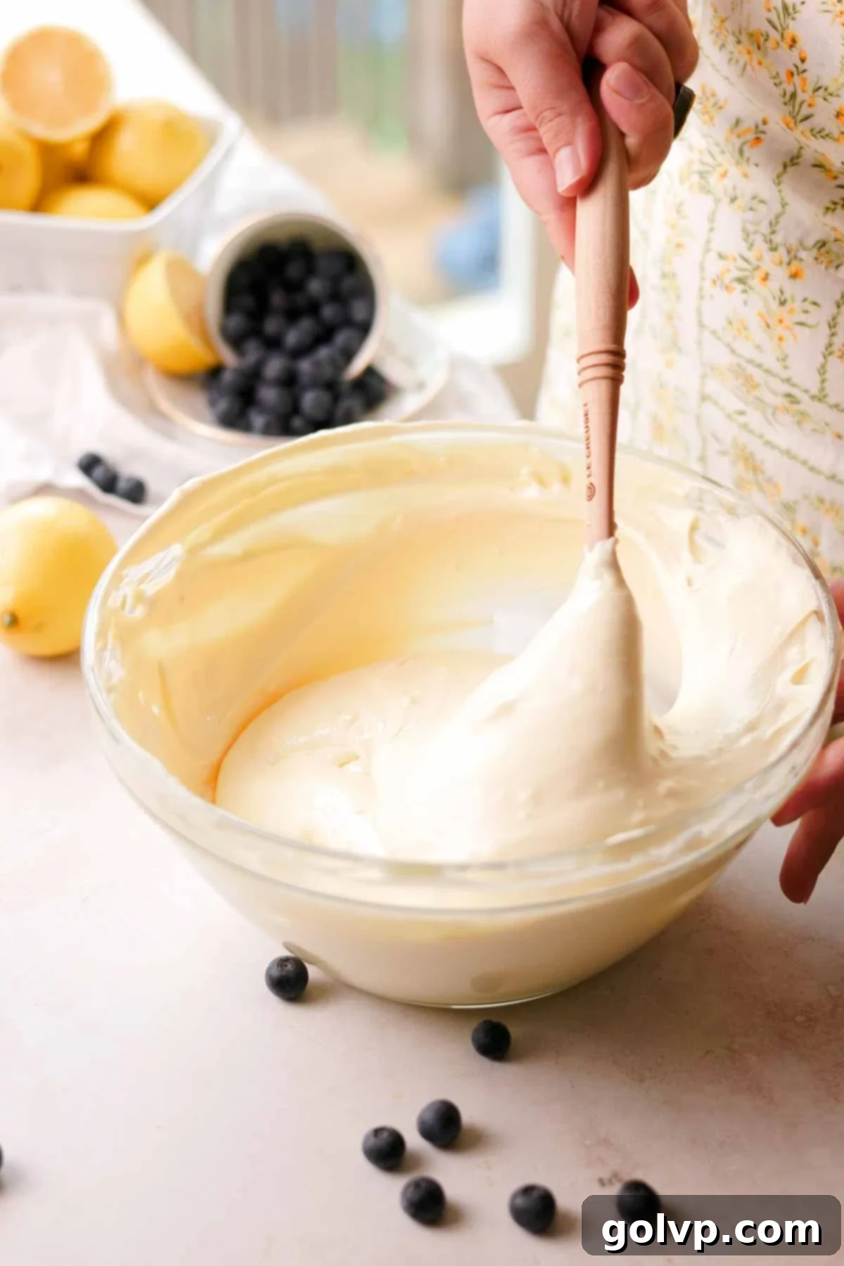 mixing vanilla cheesecake batter with a spatula