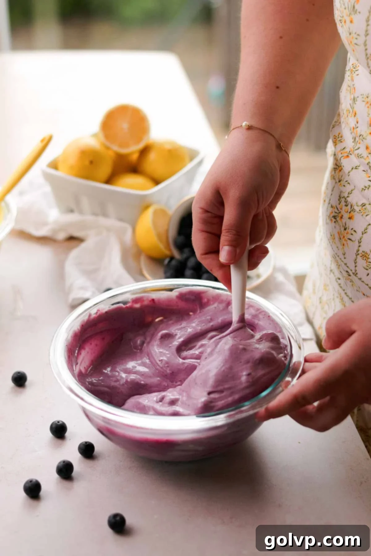 mixing the blueberry cheesecake batter with a spatula