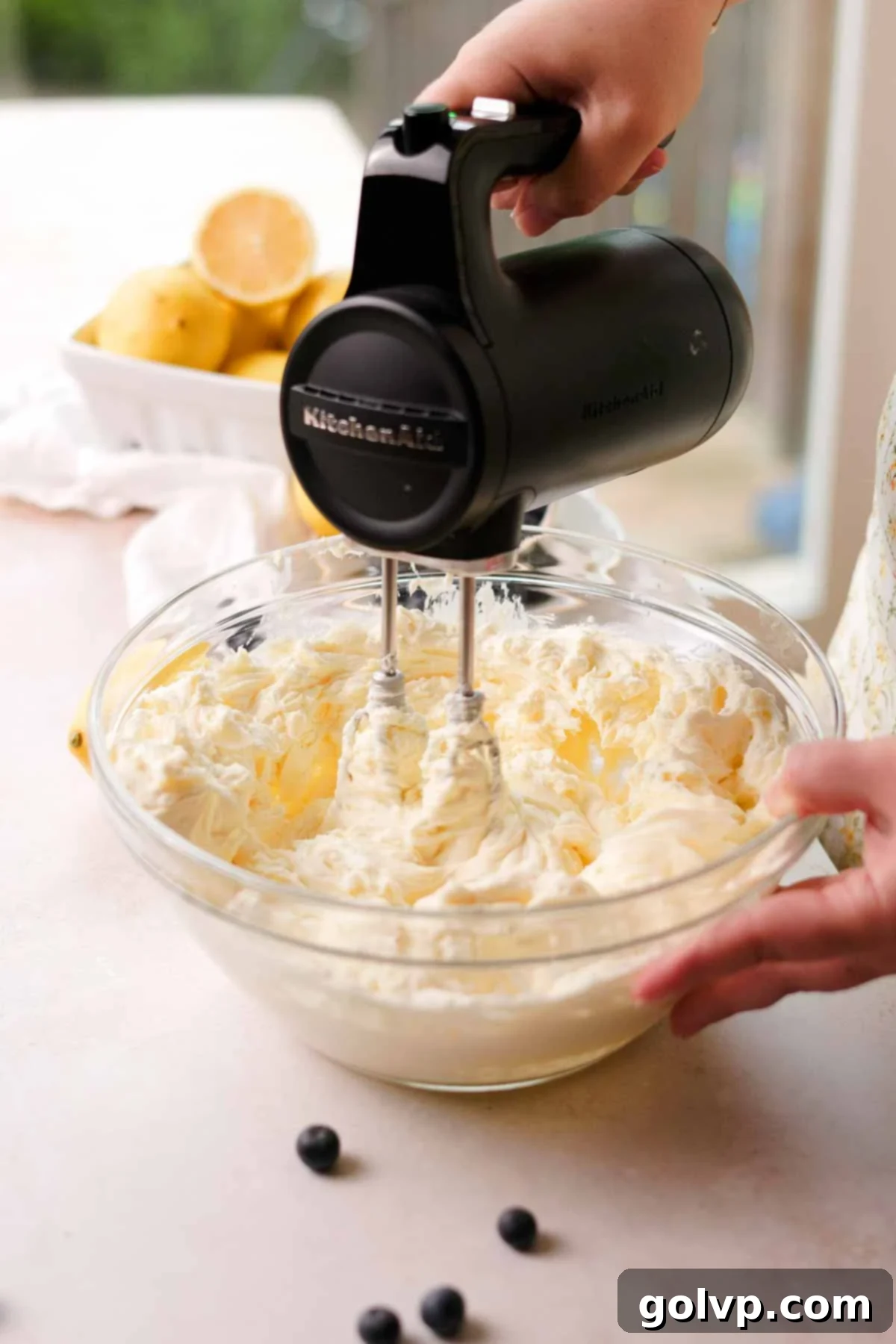 mixing cream cheese and sugar with an electric mixer