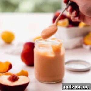 Scooping rich peach curd with a spoon from a glass jar, showing its creamy texture