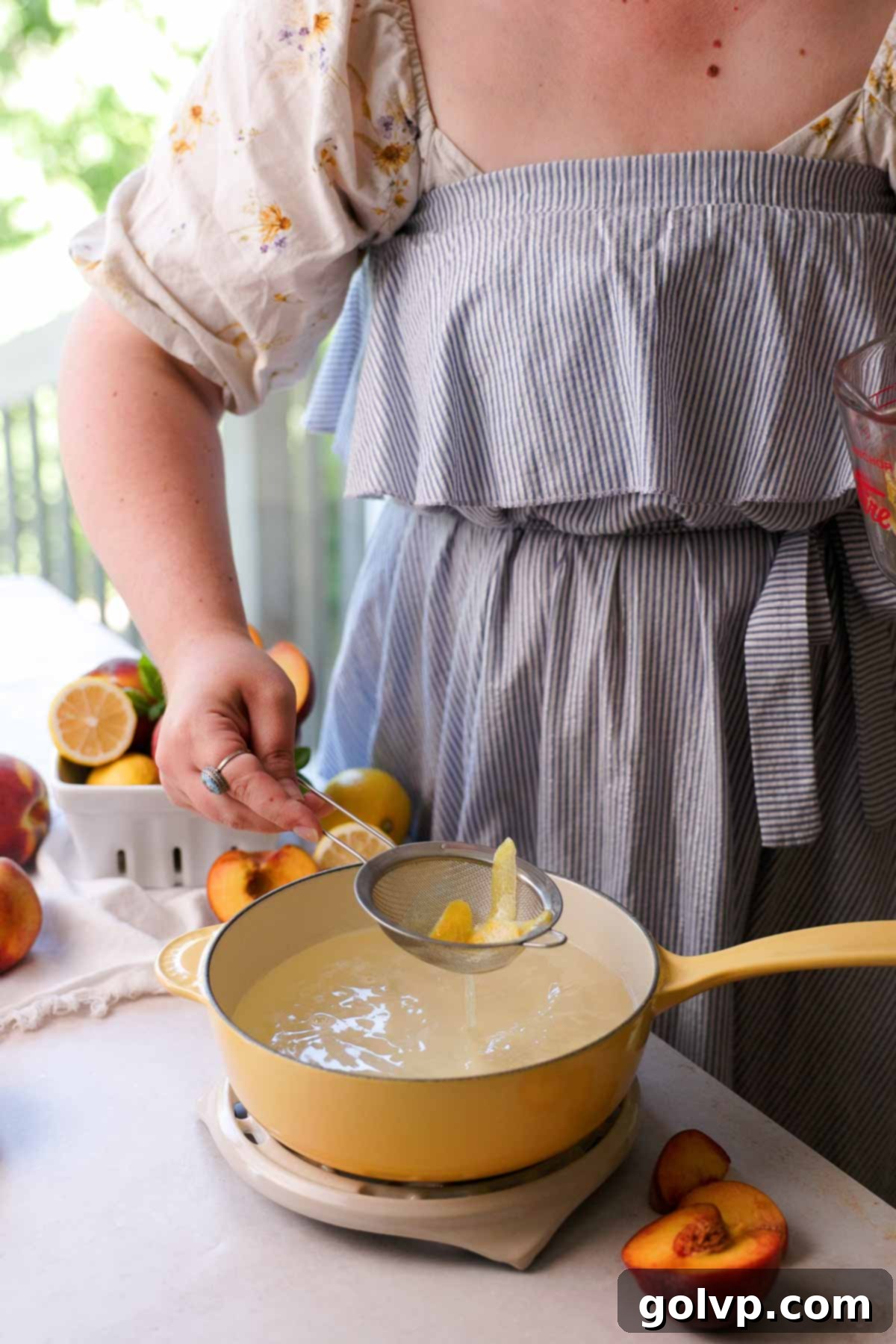 straining lemon peels from the syrup