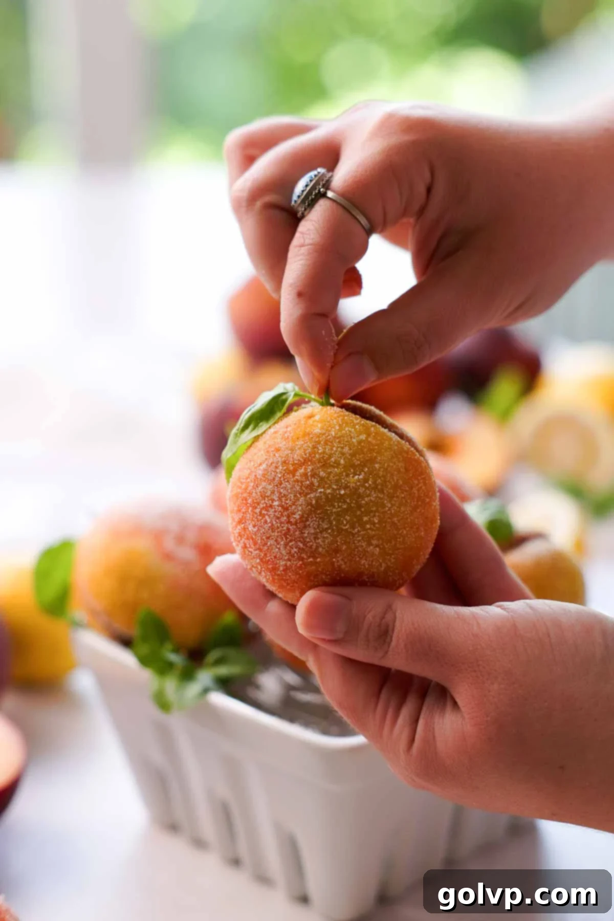 placing a basil leaf into a finished peach italian cookie