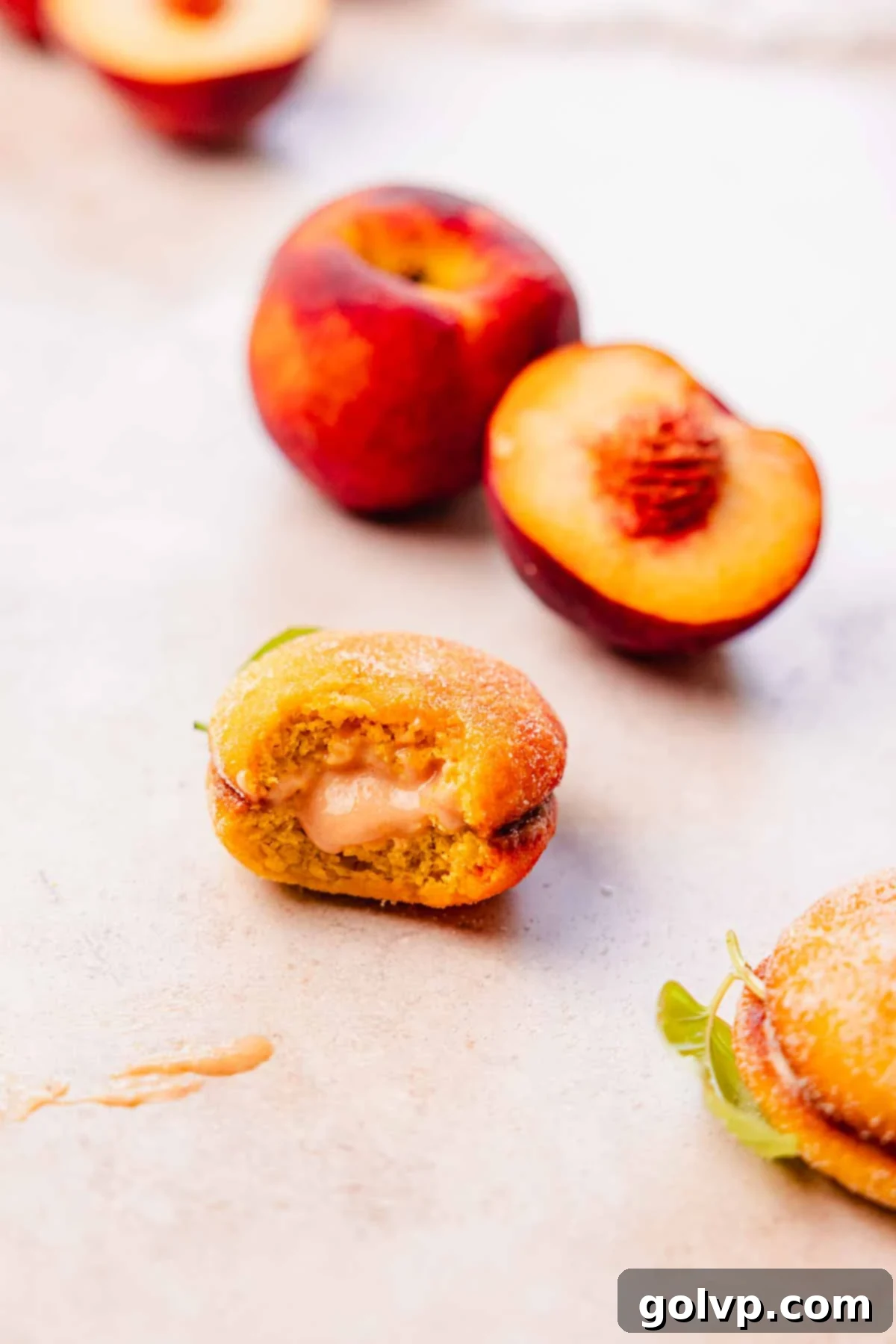 bitten italian cookie with peach curd oozing out of the middle
