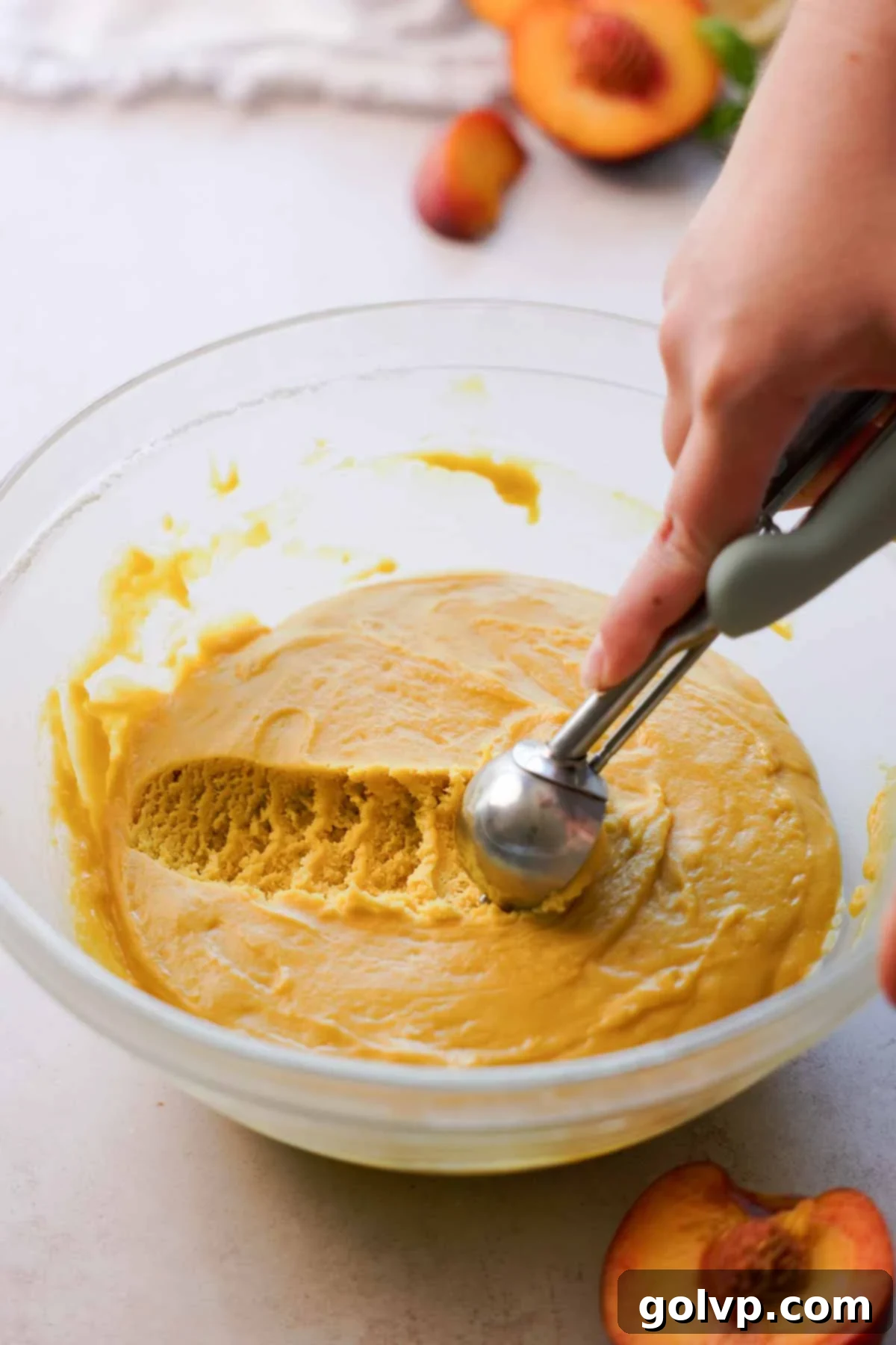 scooping the italian peach cookie dough from a glass bowl