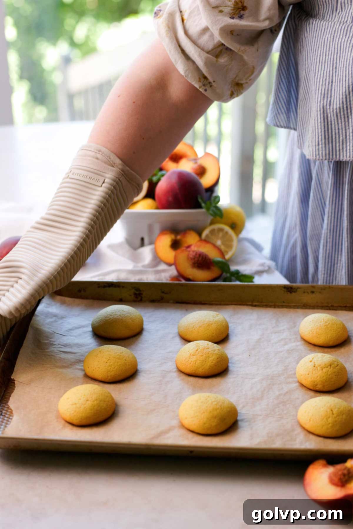 freshly baked peach italian cookies sitting on a baking tray
