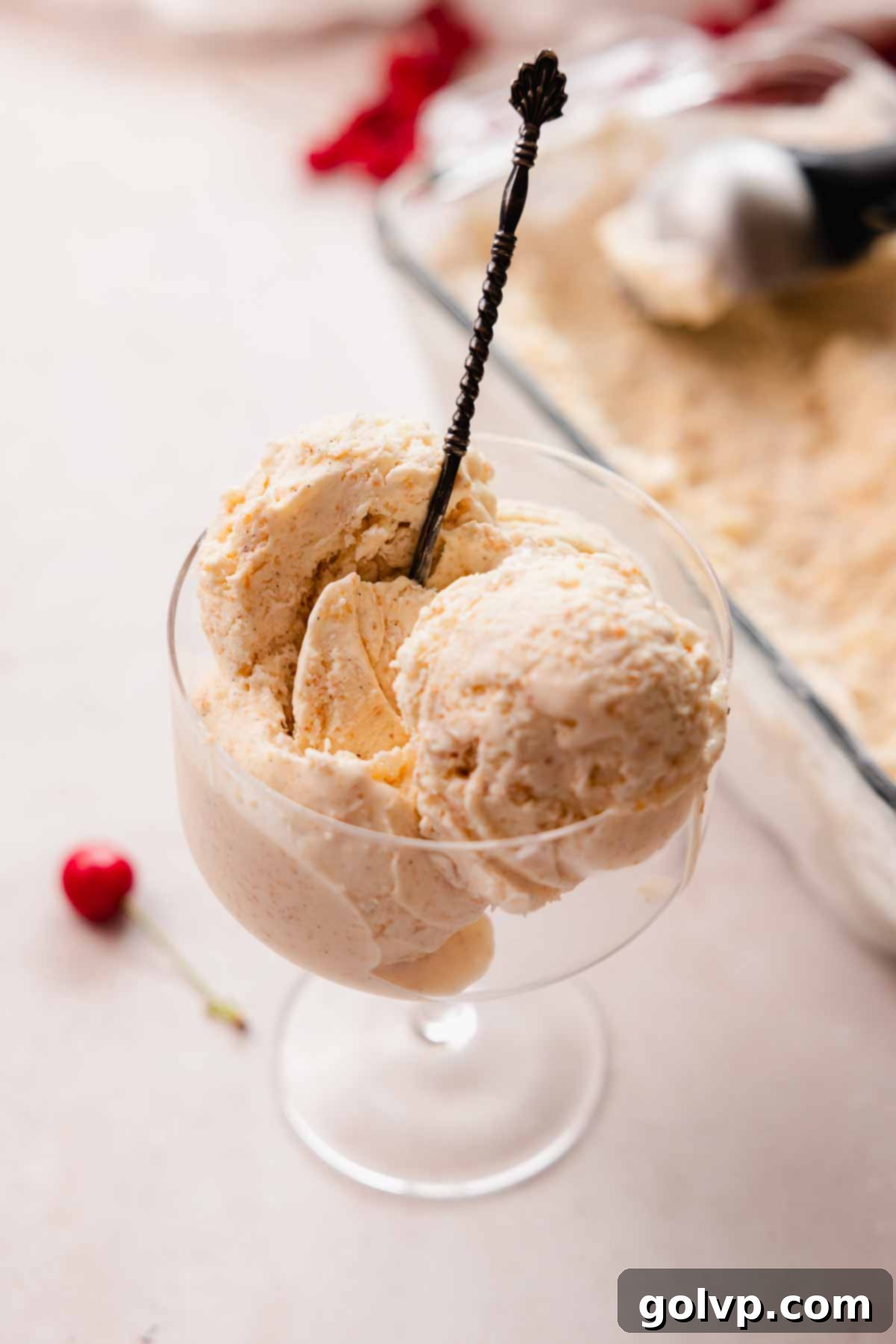 Closeup shot of creamy brown butter ice cream in a glass, highlighting its smooth texture and vanilla specks.