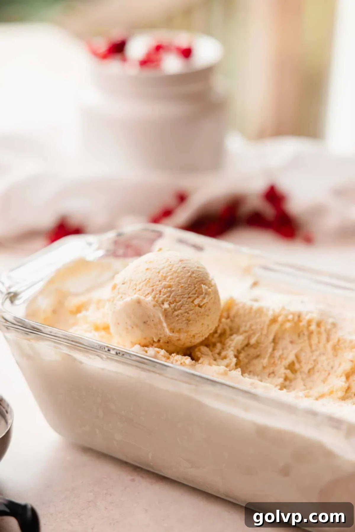 Nutty Brown Butter Ice Cream 12 A perfectly scooped ball of vanilla brown butter ice cream resting on a tray of more ice cream.
