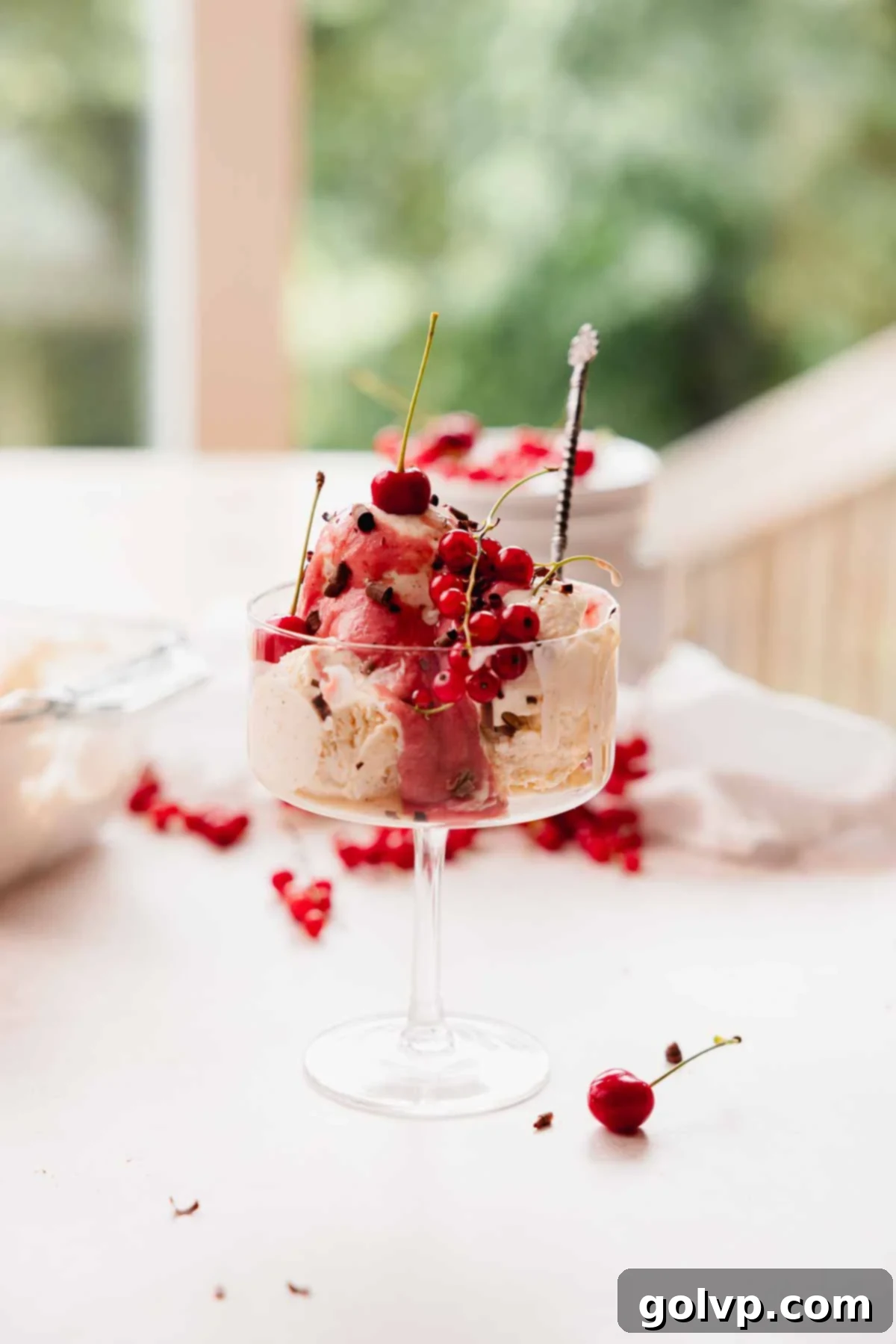 Nutty Brown Butter Ice Cream 13 Brown butter ice cream served in a clear glass, beautifully topped with fresh cherries and vibrant red currants.