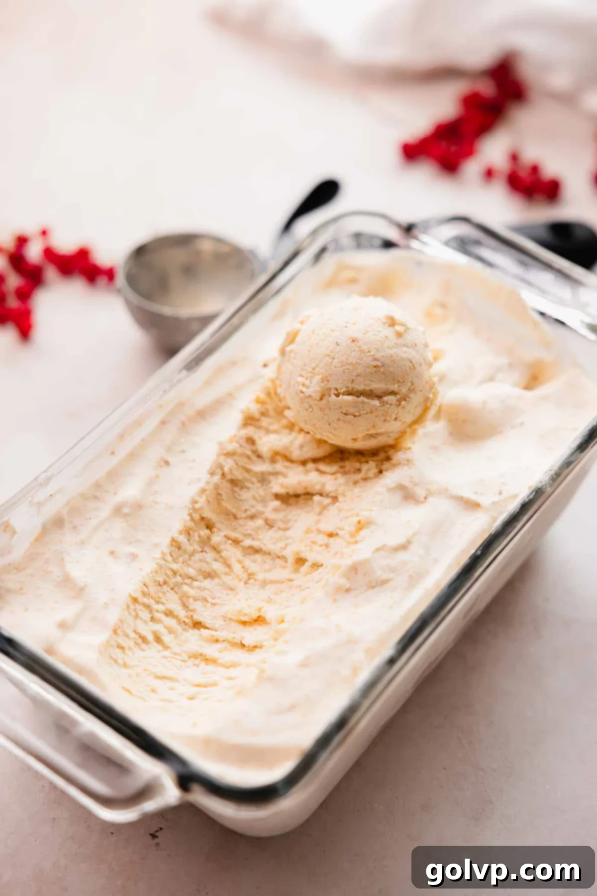 Nutty Brown Butter Ice Cream 3 A glass tray filled with smooth brown butter ice cream, with a scoop resting invitingly on top.