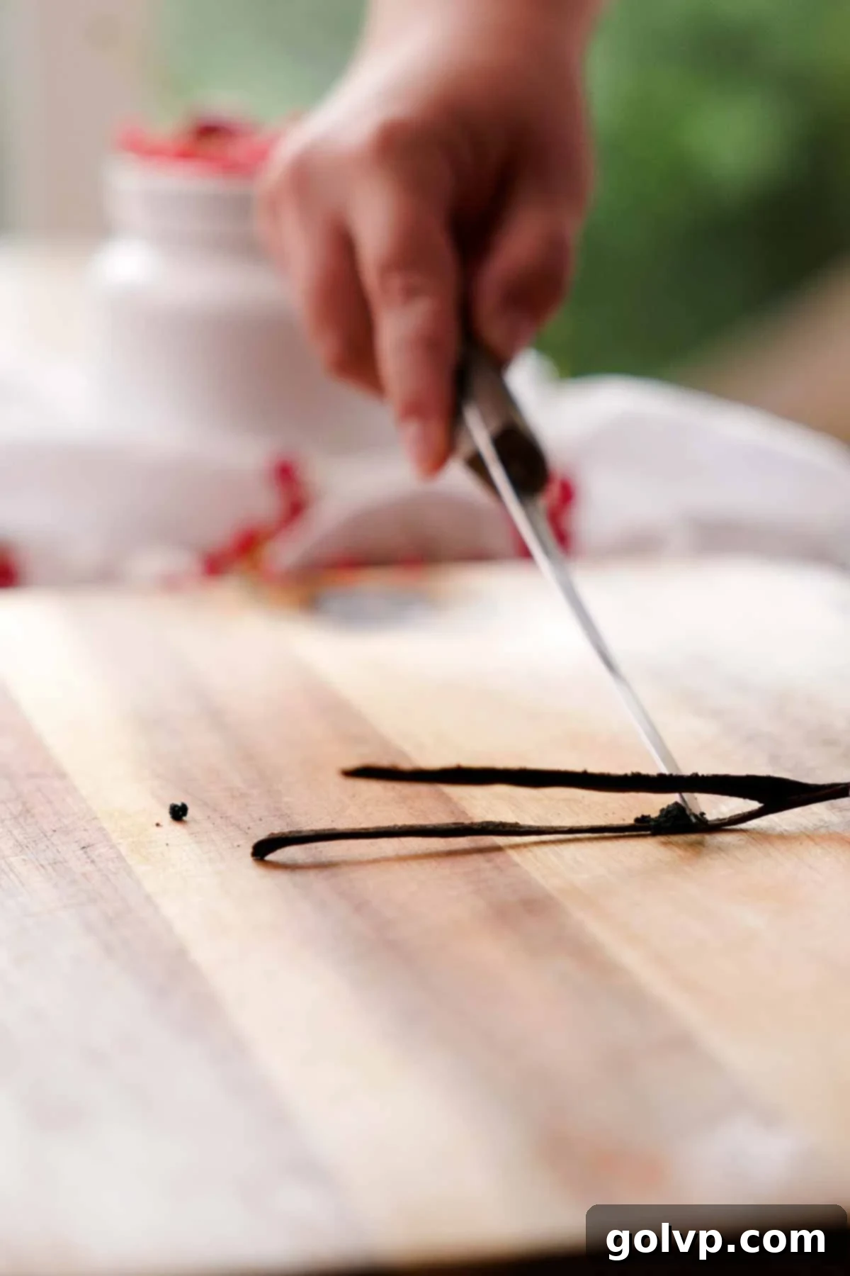 Nutty Brown Butter Ice Cream 7 Scraping fragrant vanilla bean seeds from a pod with a knife.