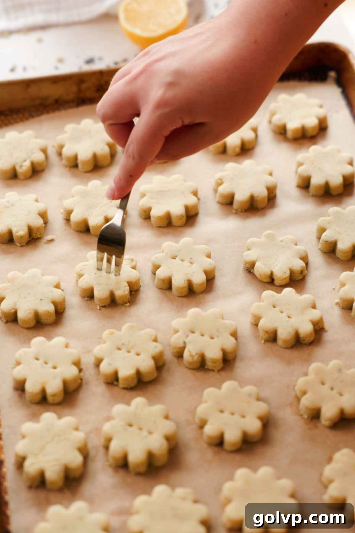 poking holes with a knife into flower shaped lavender shortbread