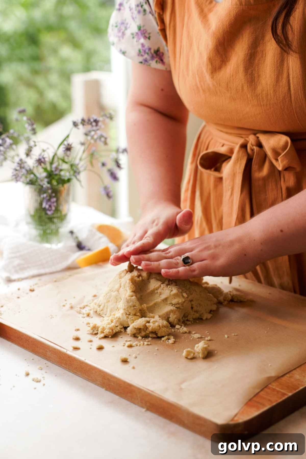 pressing lavender shortbread cookie dough together on cutting board