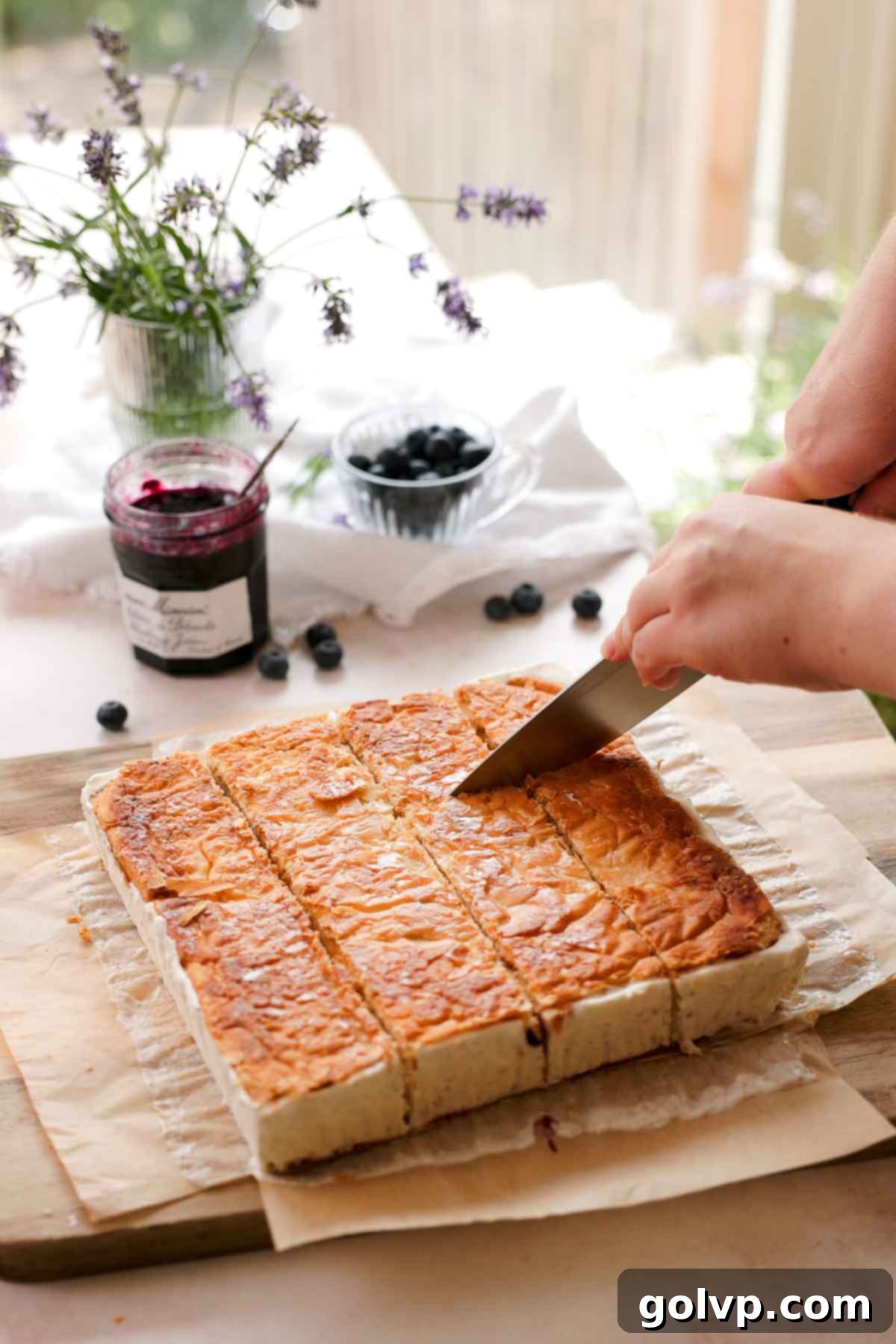 cutting puff pastry ice cream sandwiches into individual rectangles on a cutting board