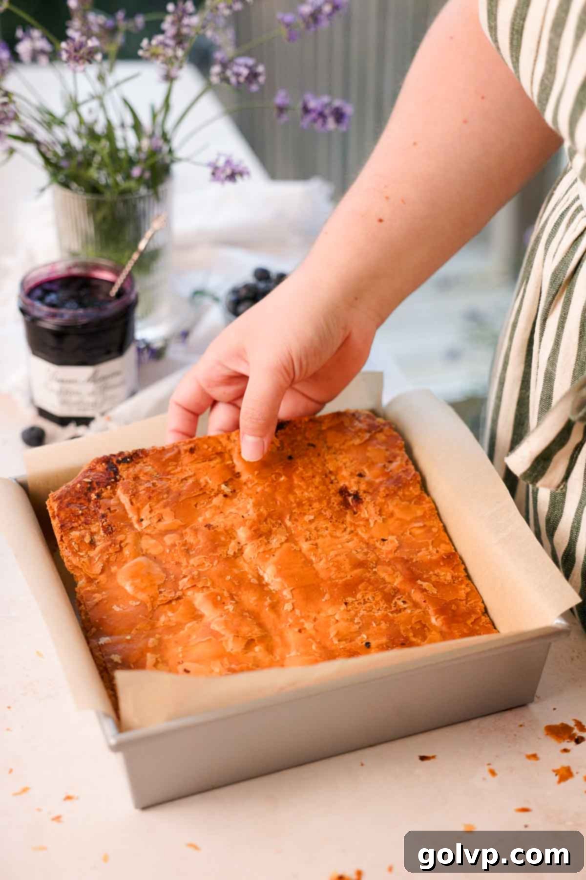 placing the bottom piece of puff pastry into a parchment-lined baking pan