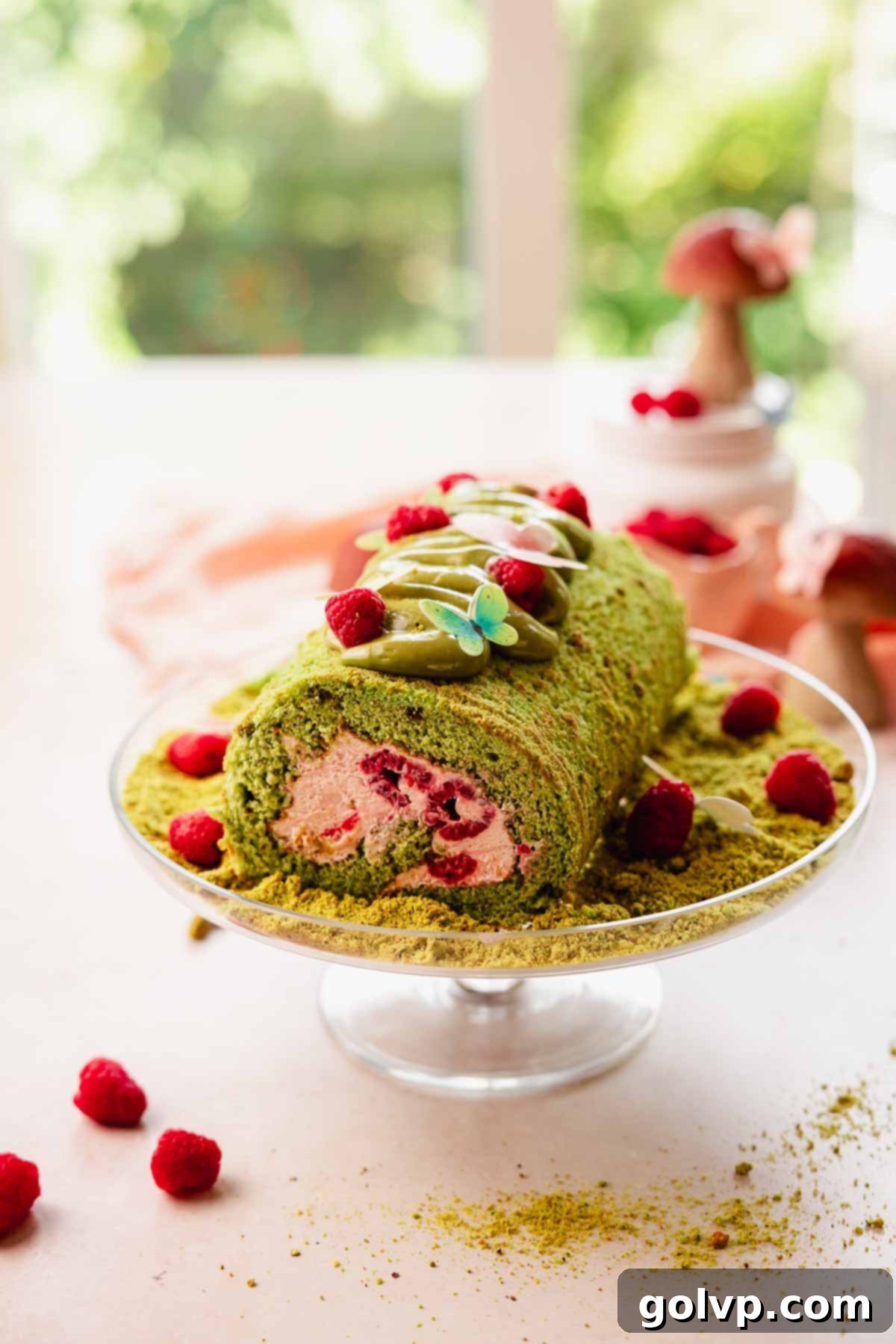 raspberry pistachio cake roll on cake plate