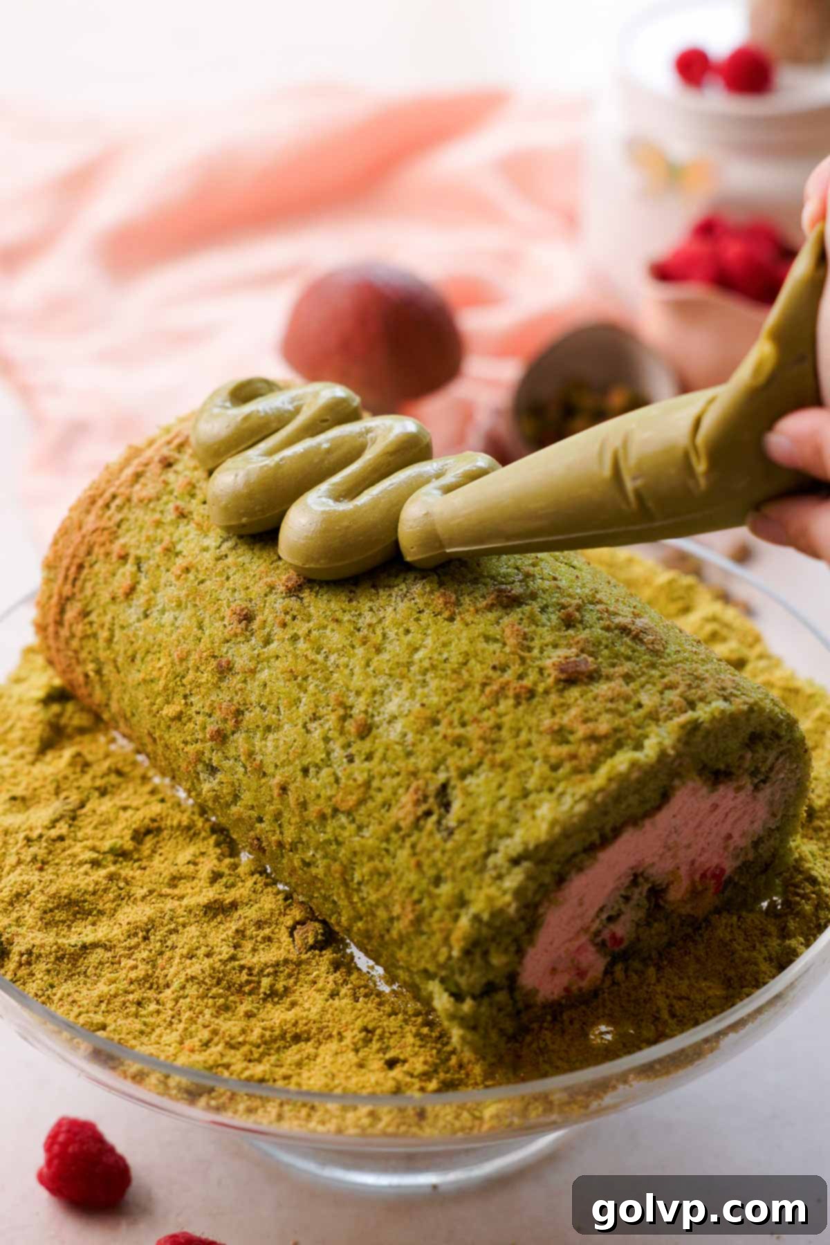 piping pistachio spread on top of roll cake