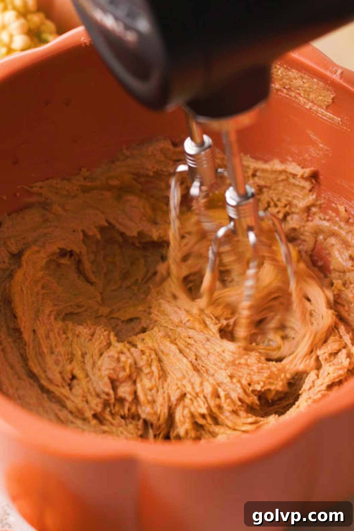beating pumpkin spice cookie wet ingredients in bowl