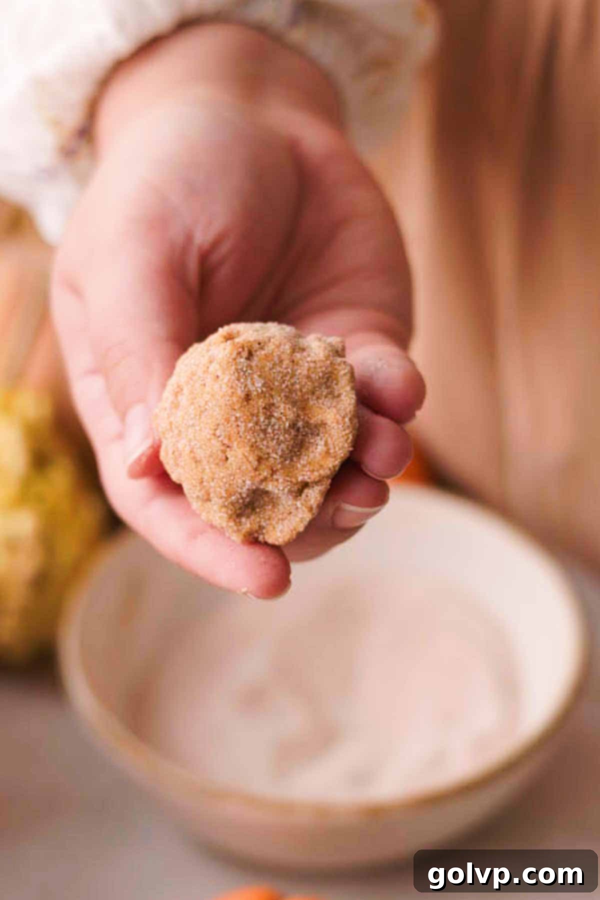 coating cookie dough ball in pumpkin spice sugar