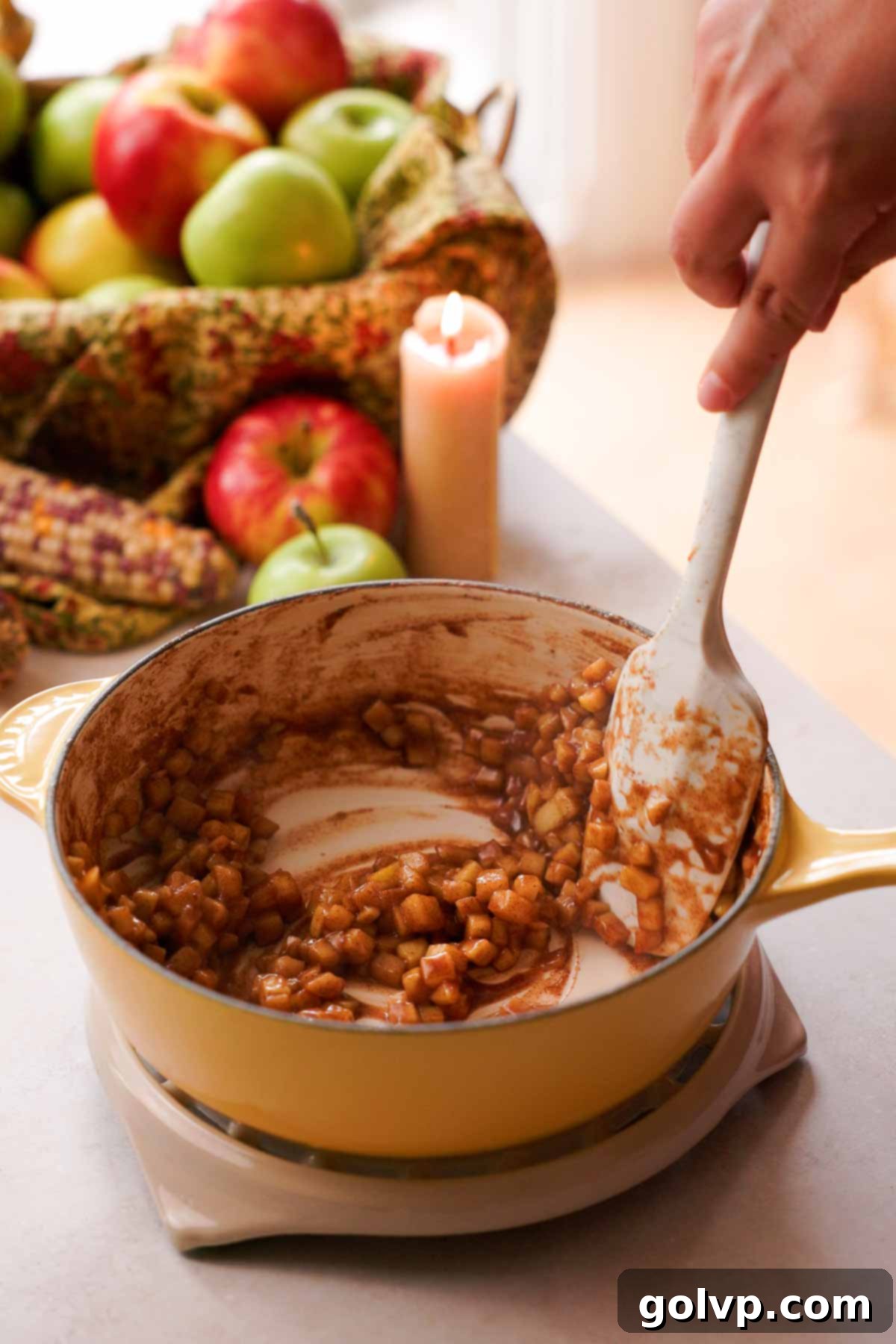 Stirring the thickened and cooked apple pie filling in a pan