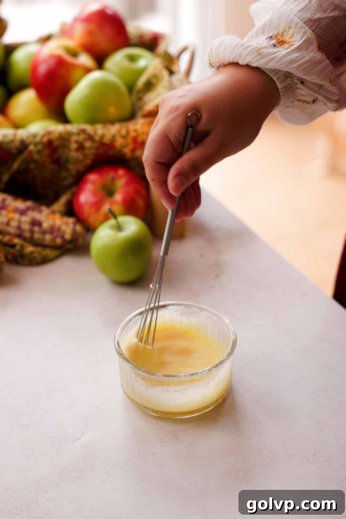Whisking an egg wash mixture with a mini wire whisk in a small bowl