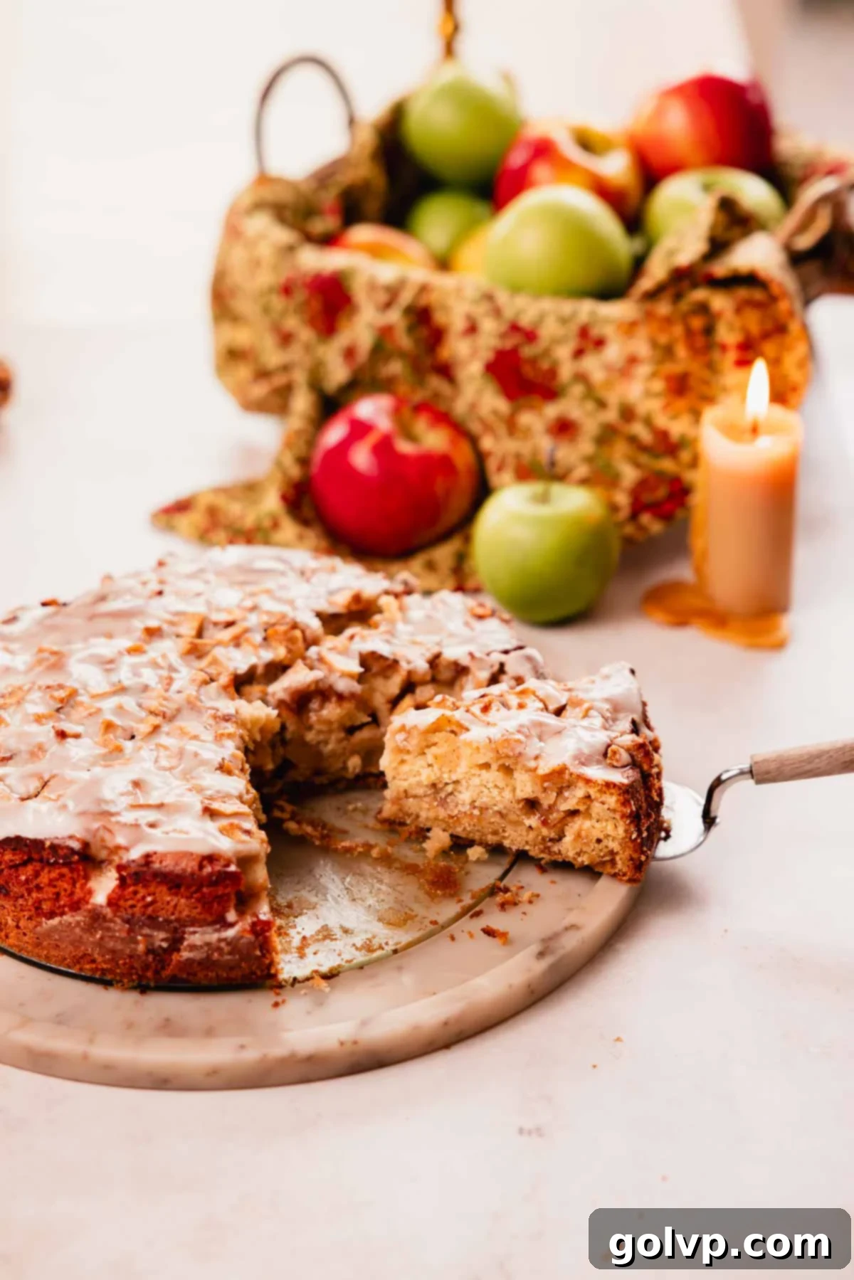 slice of apple fritter cake with vanilla glaze on a cake spatula