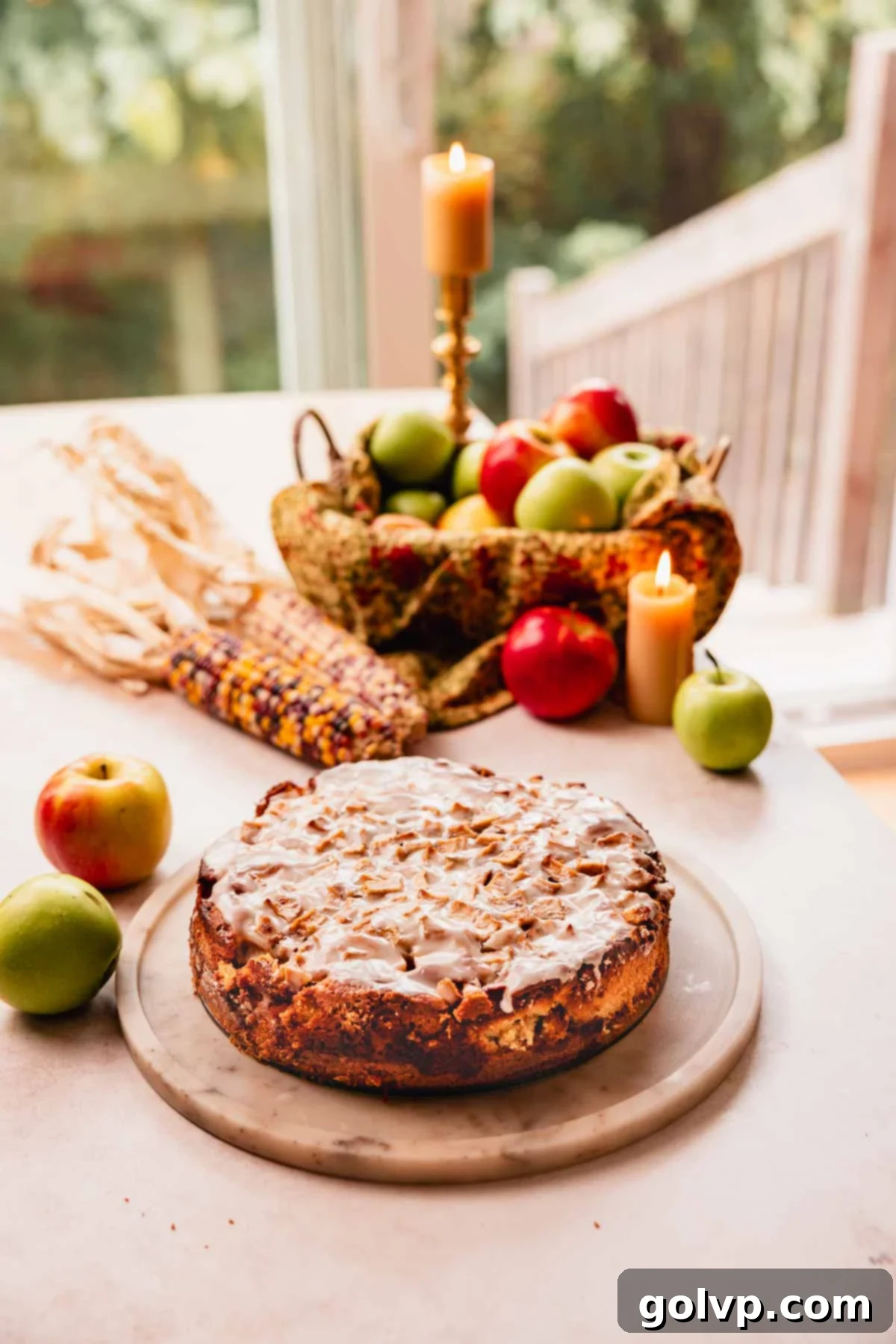 glazed apple fritter cake on marble plate with candles