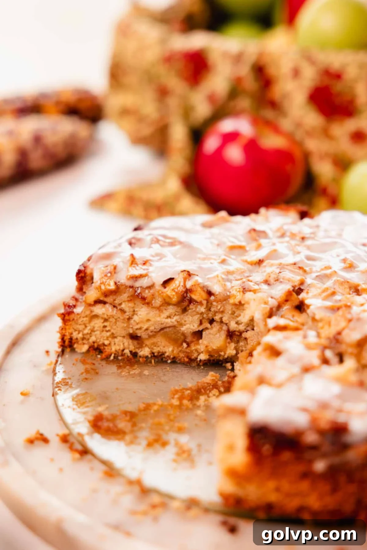 slice of apple fritter cake on cake plate with glaze